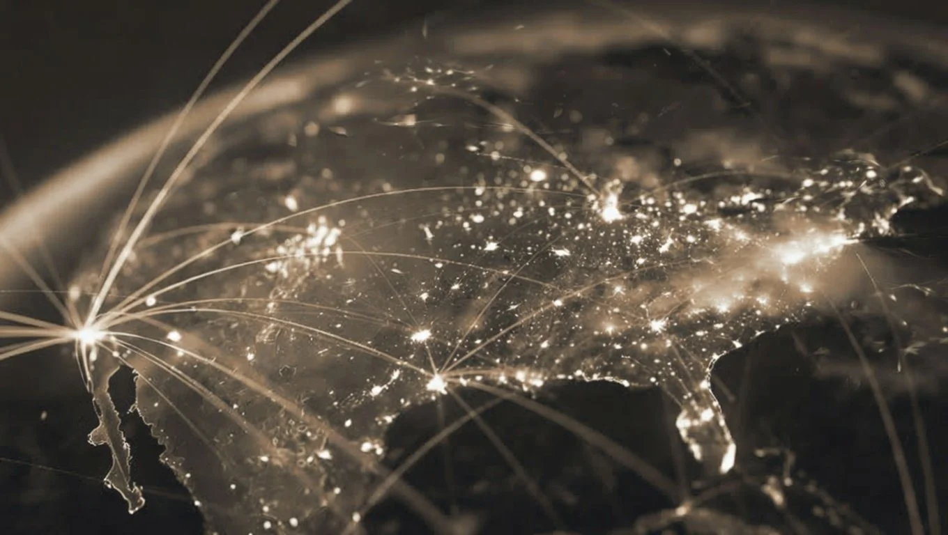Dark image of a world map illuminated with bright lights at major cities, with lines connecting different locations, representing global connections.