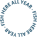 Circular black logo with blue text around the edge that reads 'FISH HERE ALL YEAR'.