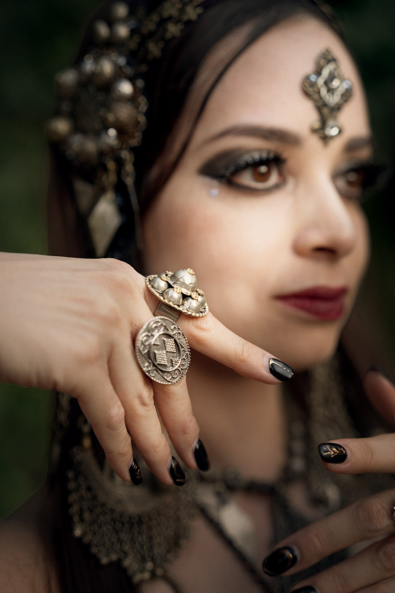 Close-up portrait of Michelle Bettridge showing her makeup, jewelry and hand detail