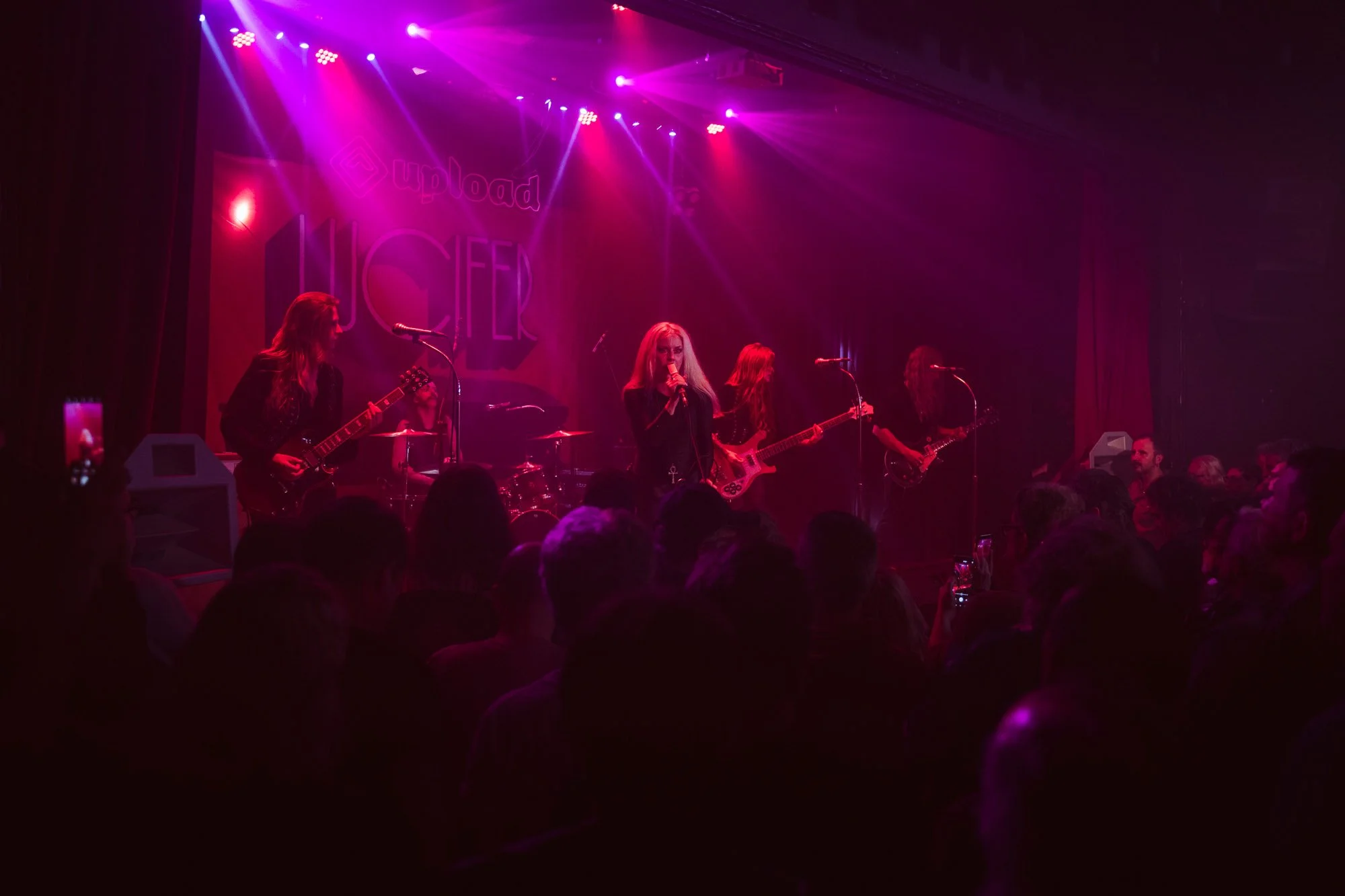 wide shot of band performing on stage with audience in foreground
