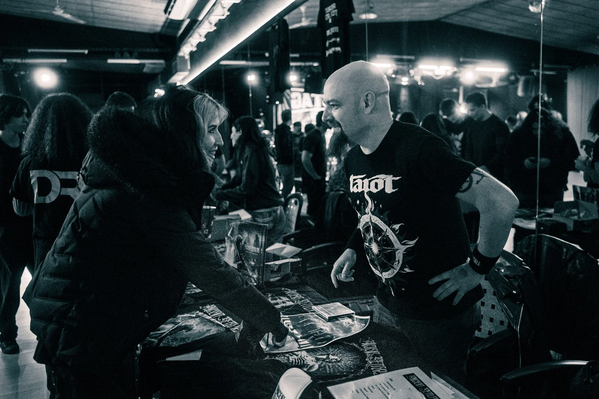 people interacting at merchandise stand during music festival