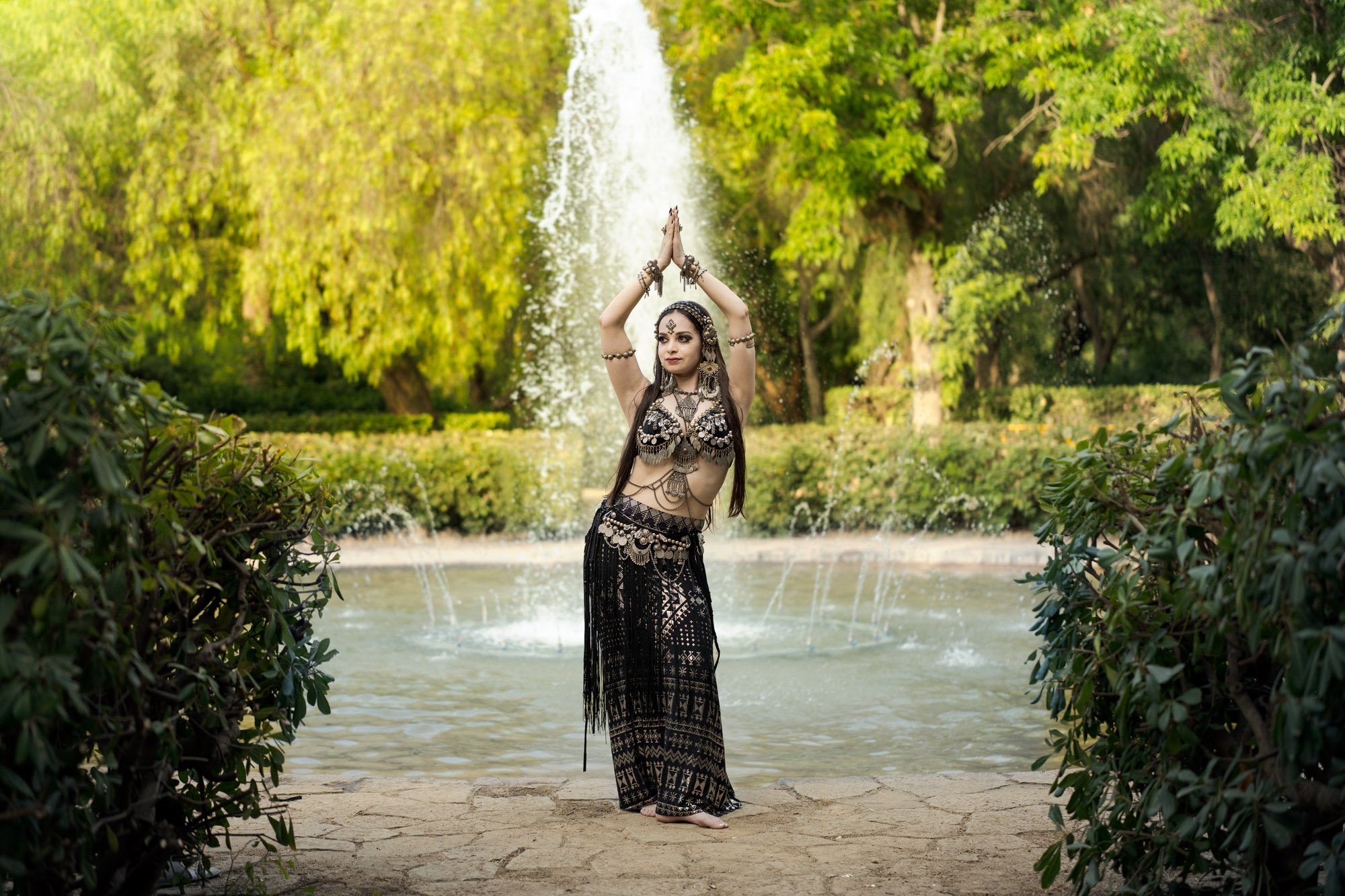 Michelle Bettridge posing in tribal fusion costume in front of a fountain at the Jardins de Laribal in Barcelona