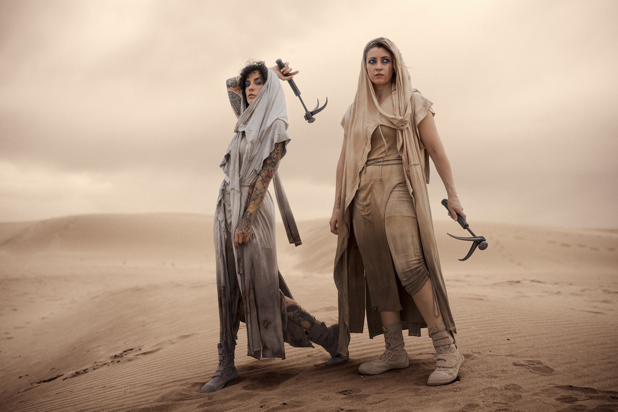 Two Fremen standing together in the desert, searching the sands for signs of Shai-Hulud