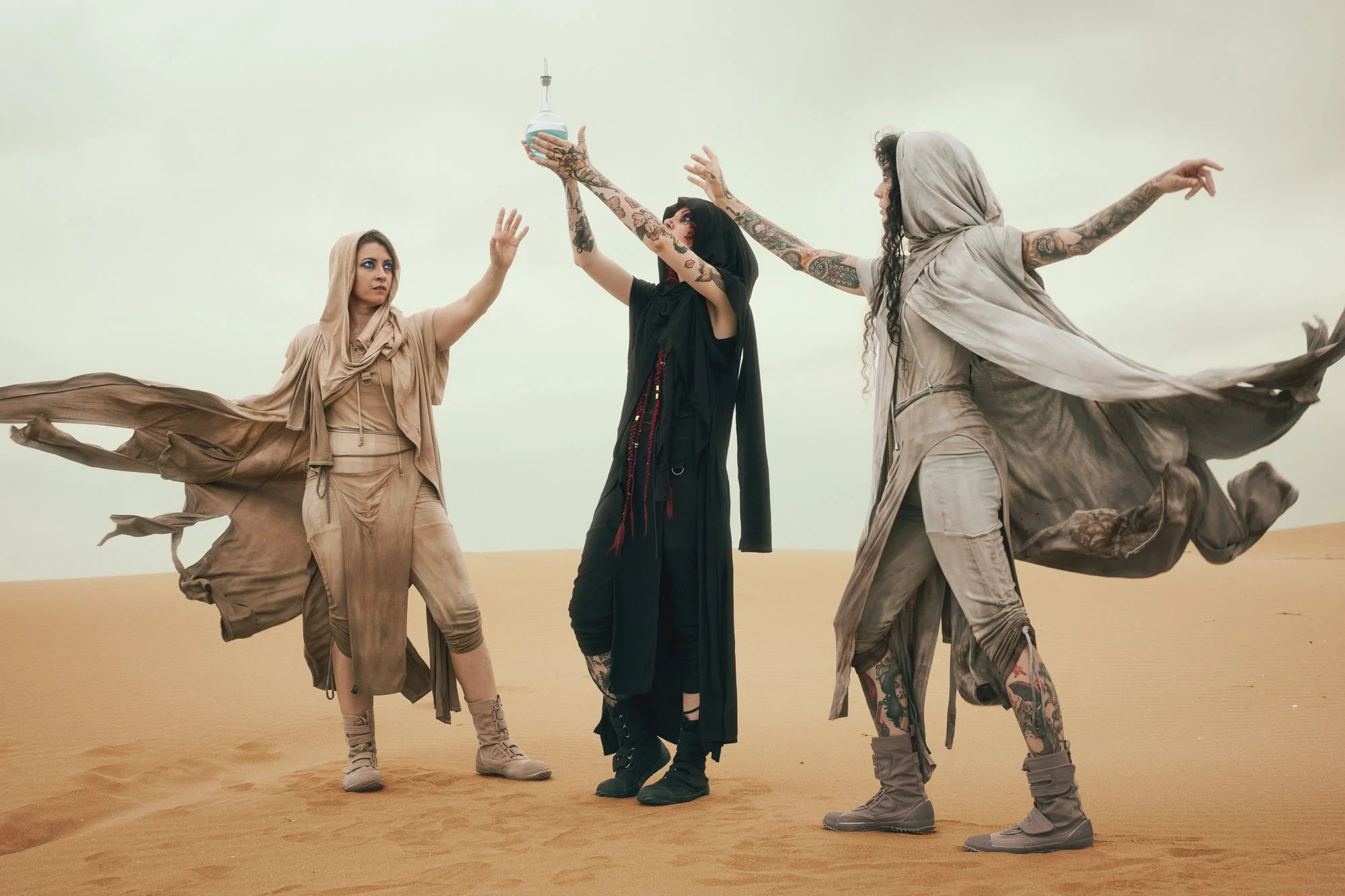 Three Dune-inspired characters performing a ritual in the desert