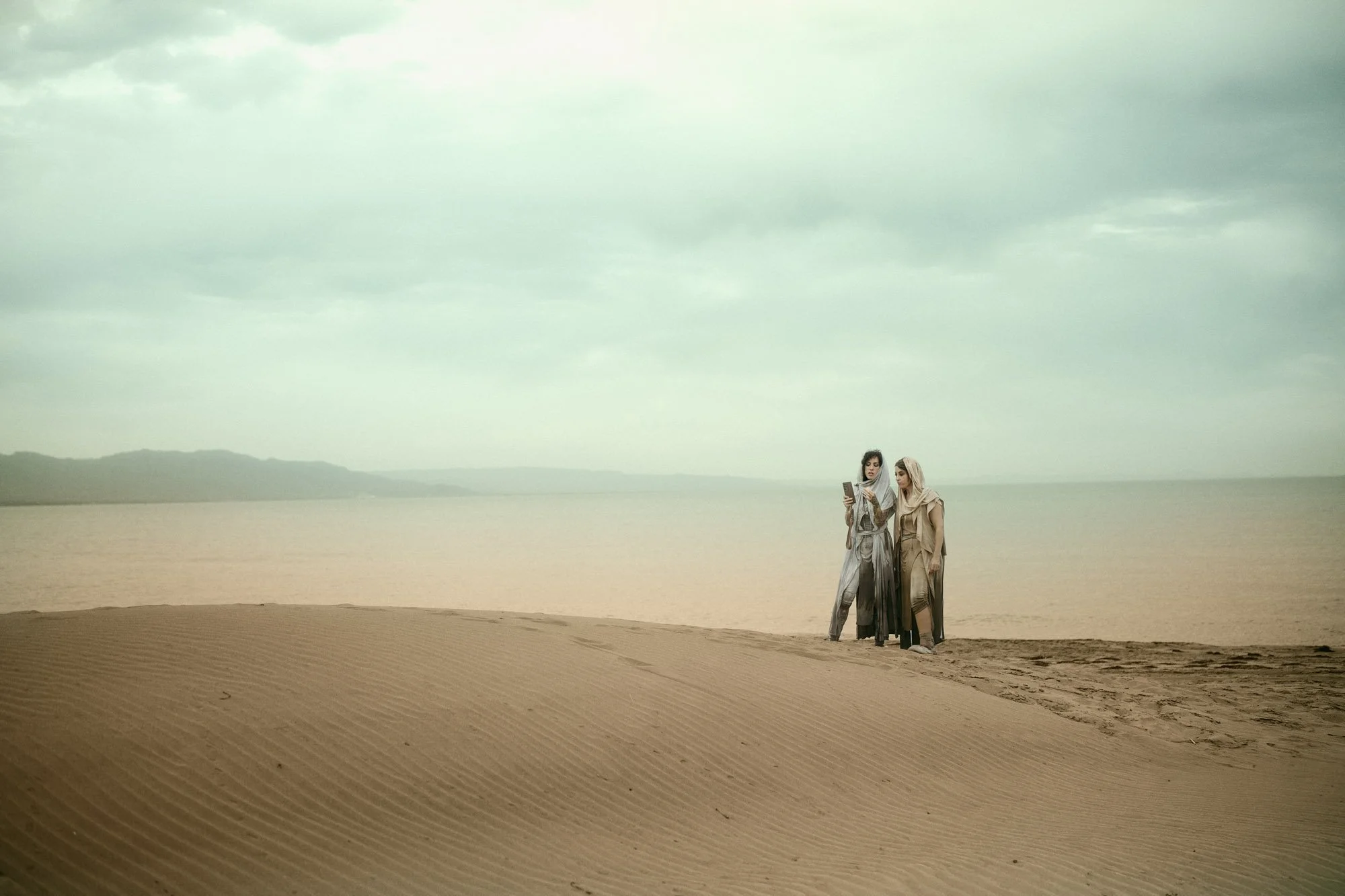 Sandra Roll standing with Lidia Martin  in a vast desert landscape, inspired by Dune
