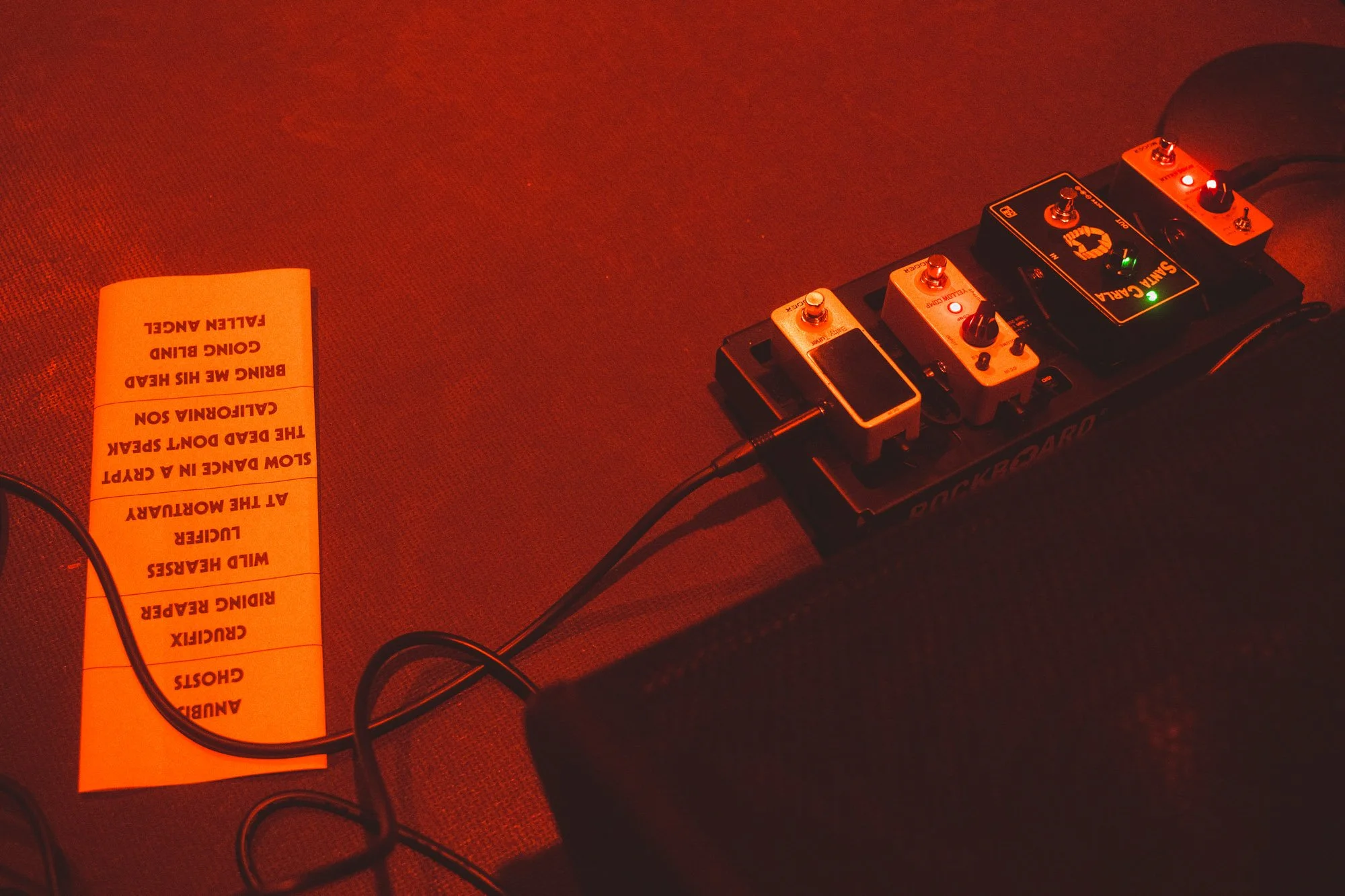 guitar pedals and setlist on stage floor before concert
