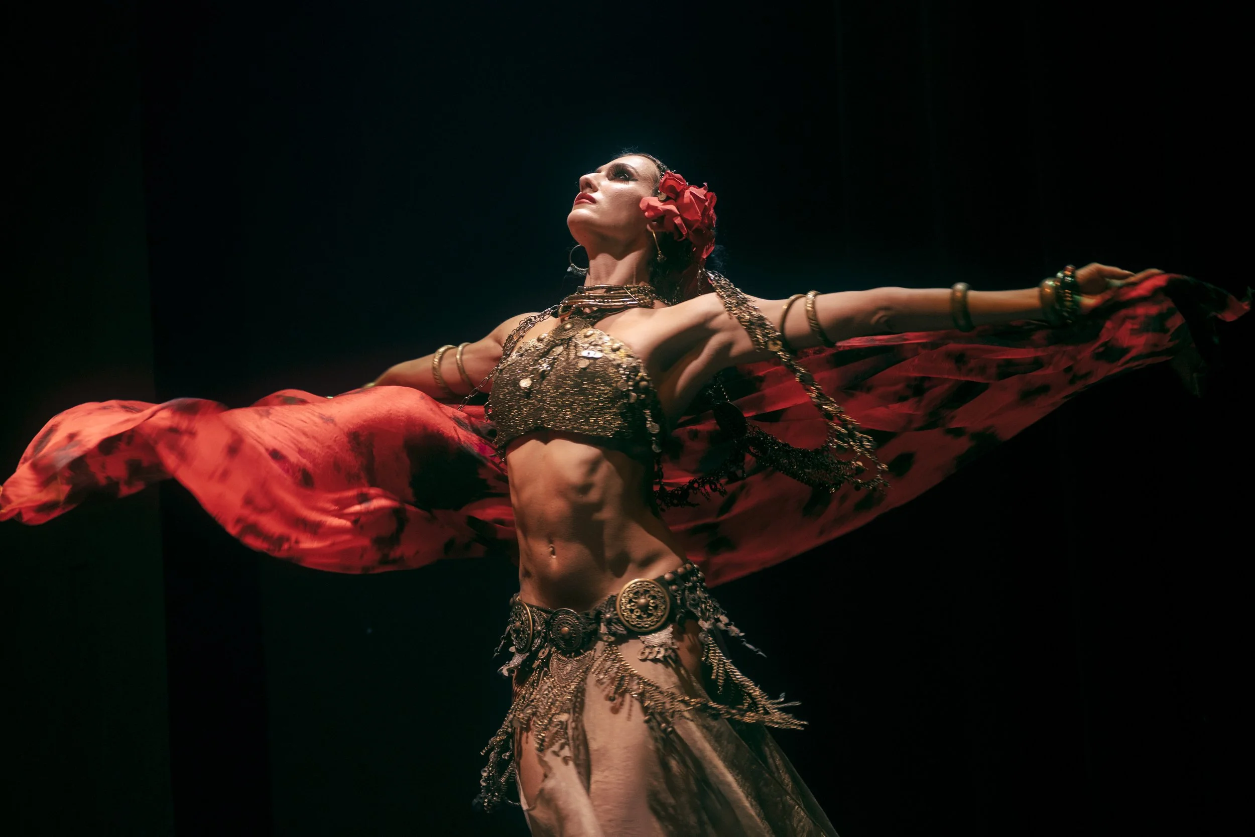 Alisa Gurova performing tribal fusion dance with flowing red veil.