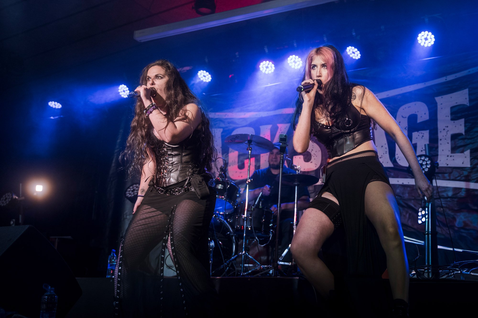 two female singers performing live on stage during metal festival