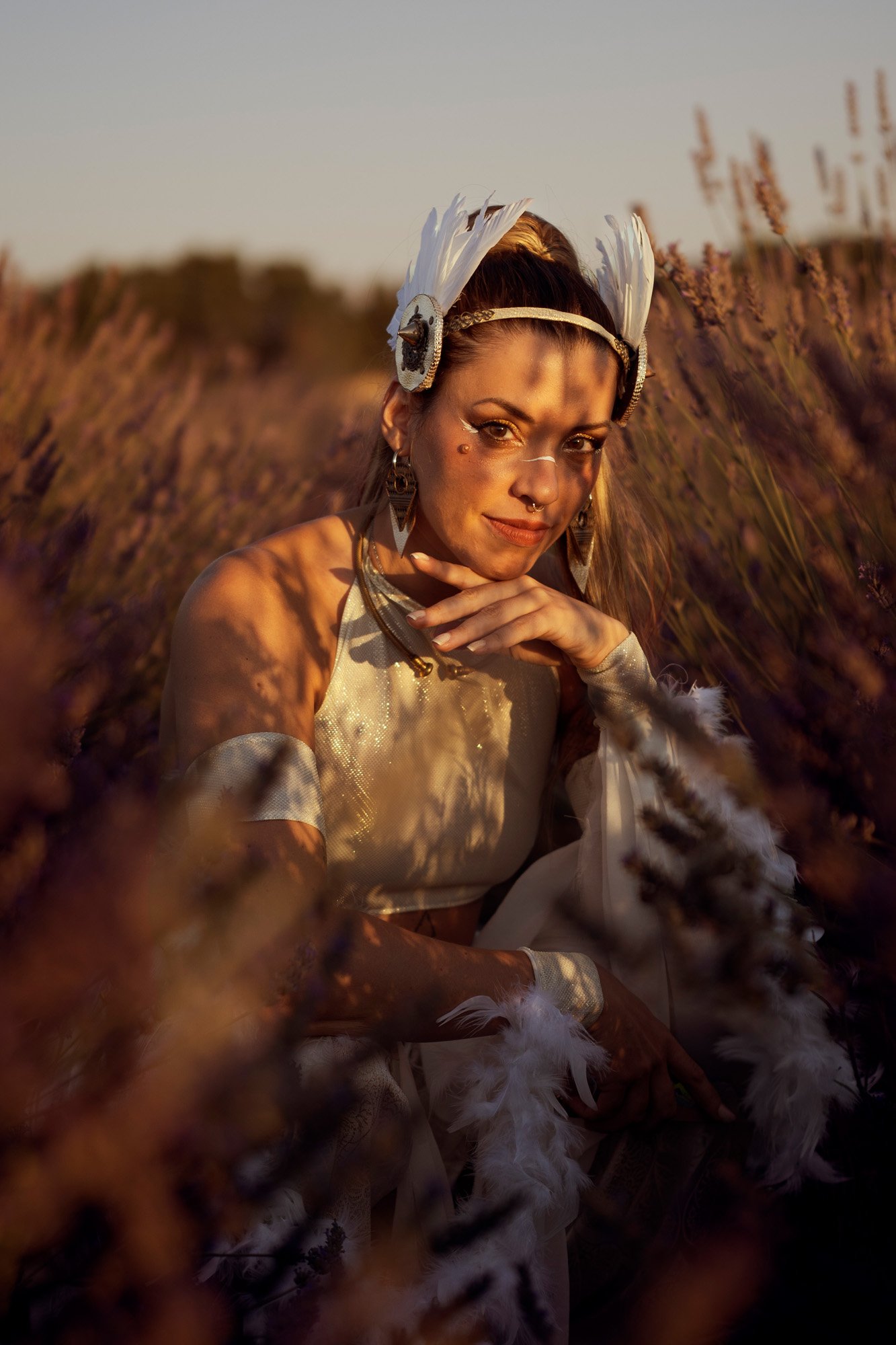Ethereal portrait of tribal fusion dancer surrounded by vegetation during golden hour.