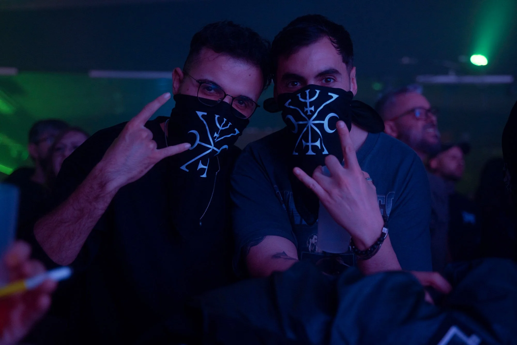 concert crowd posing with bandanas during metal show in front of stage