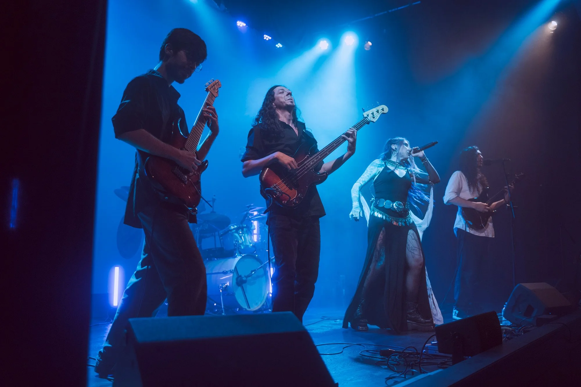 Side view of Serapis Project performing live on stage, showing all band members except the drummer.