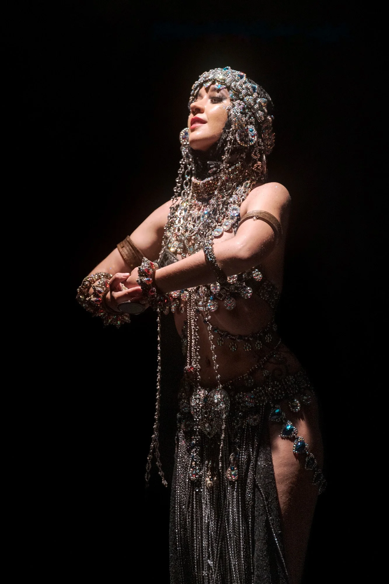 Kira Habibi Lal performing expressive arm movements in tribal fusion dance show.
