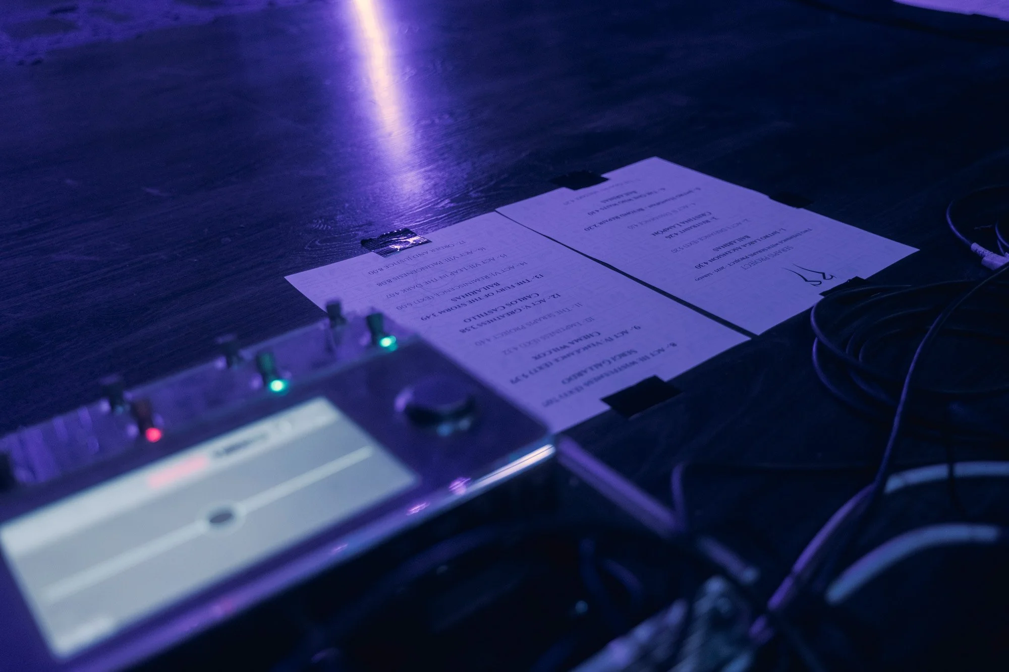 Close-up of Serapis Project handwritten setlist on stage before the concert, under blue and purple lighting.