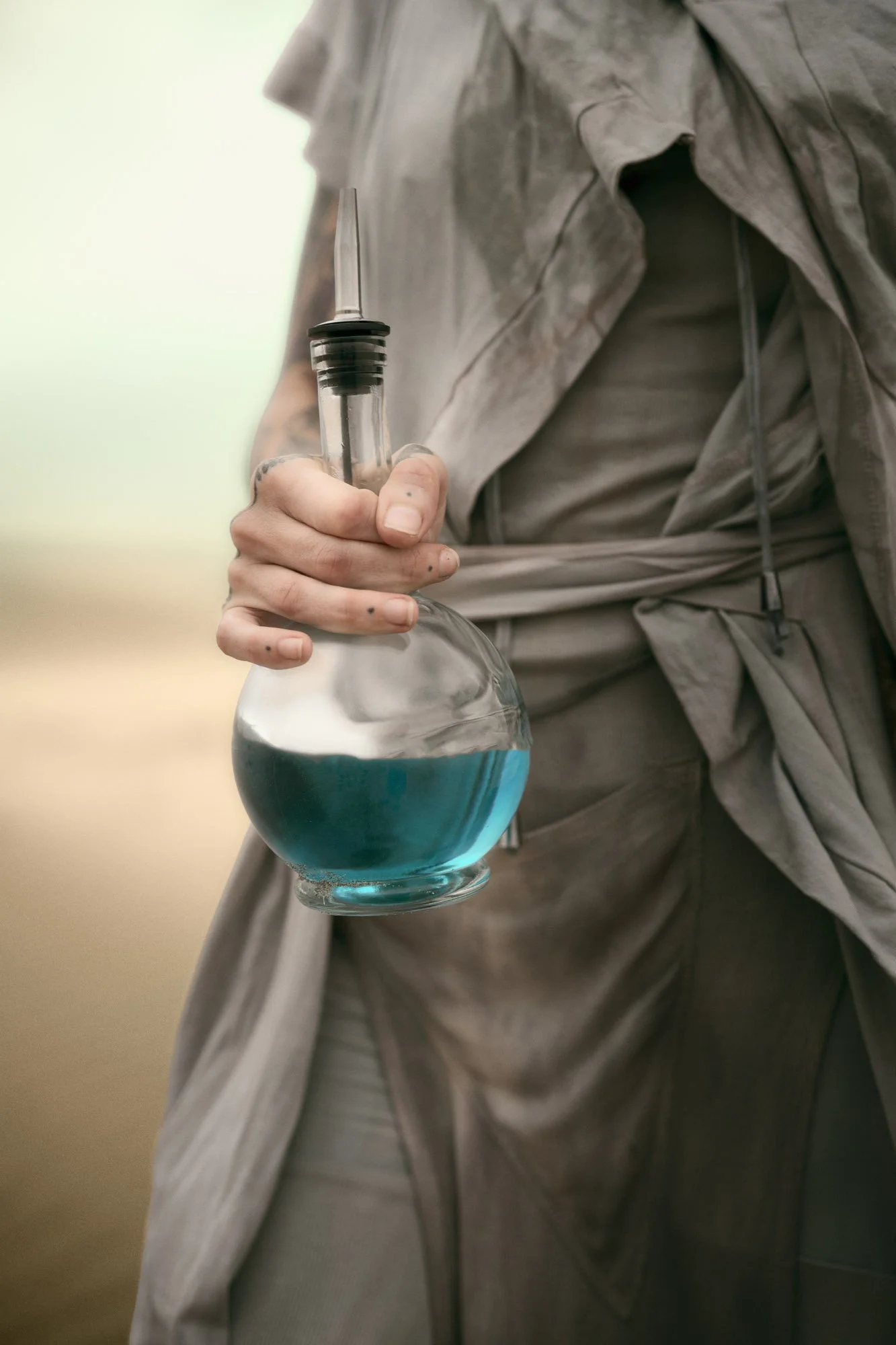 Sandra Roll holding a glass bottle representing the Water of Life in a Dune-inspired desert portrait