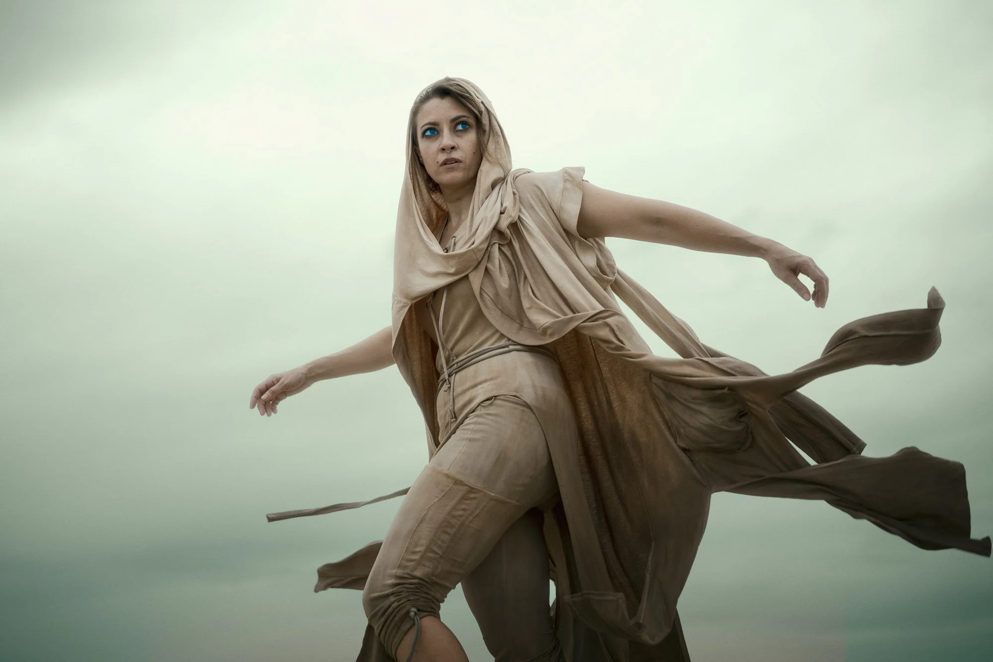 Lidia Martin moving through the desert with flowing fabric in a Dune-inspired portrait