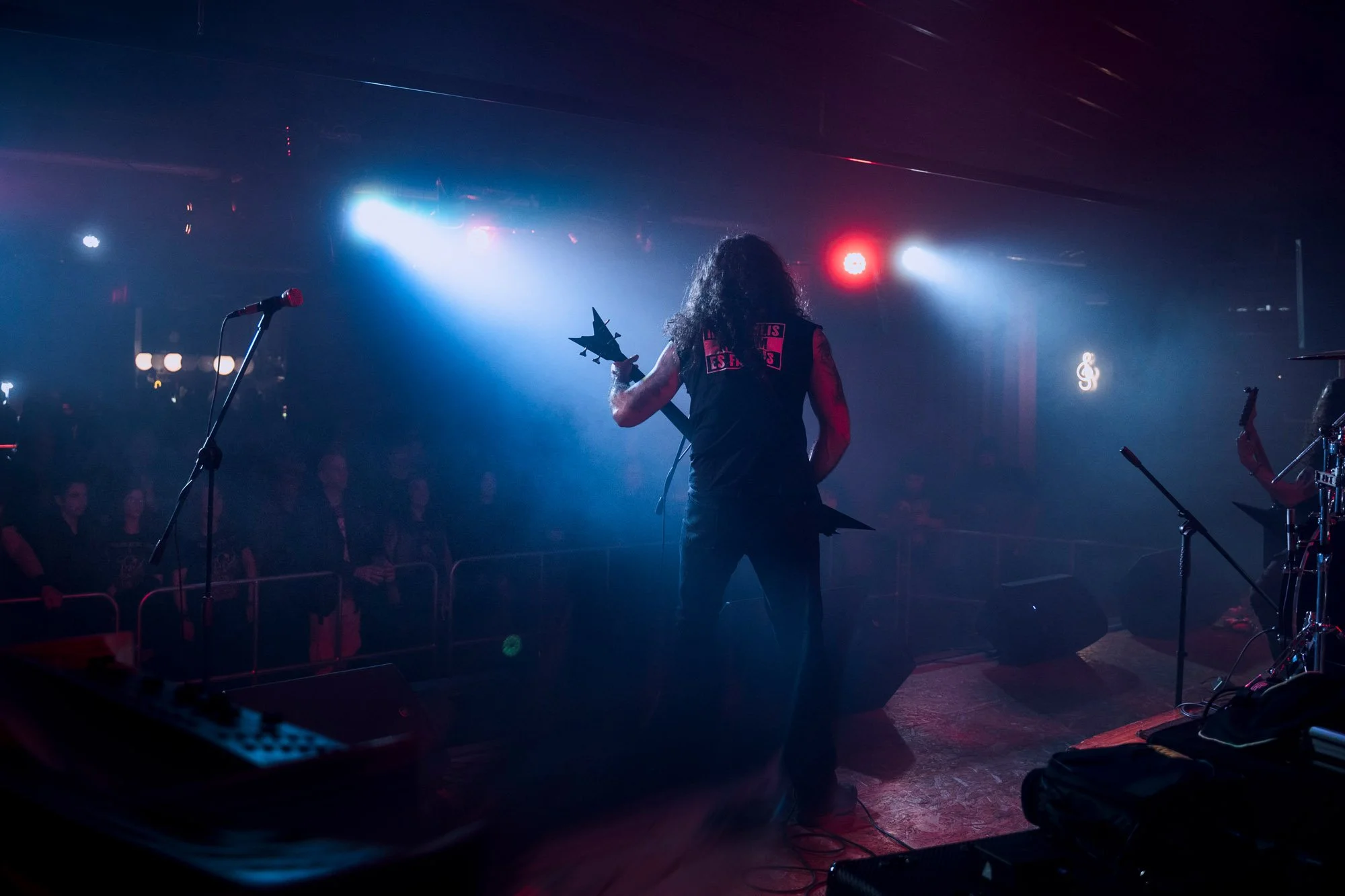 silhouette of singer performing on stage with strong backlight in metal concert