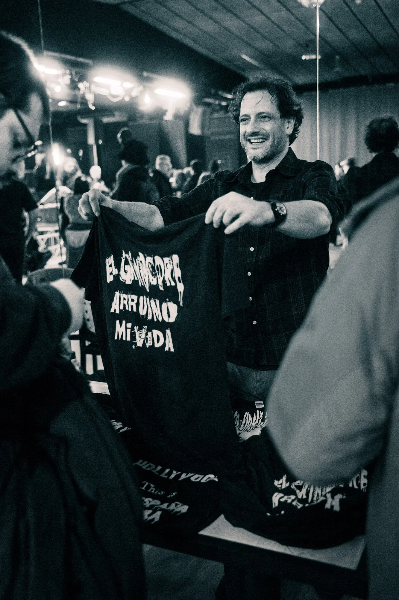 man showing band merchandise t-shirt at festival stand