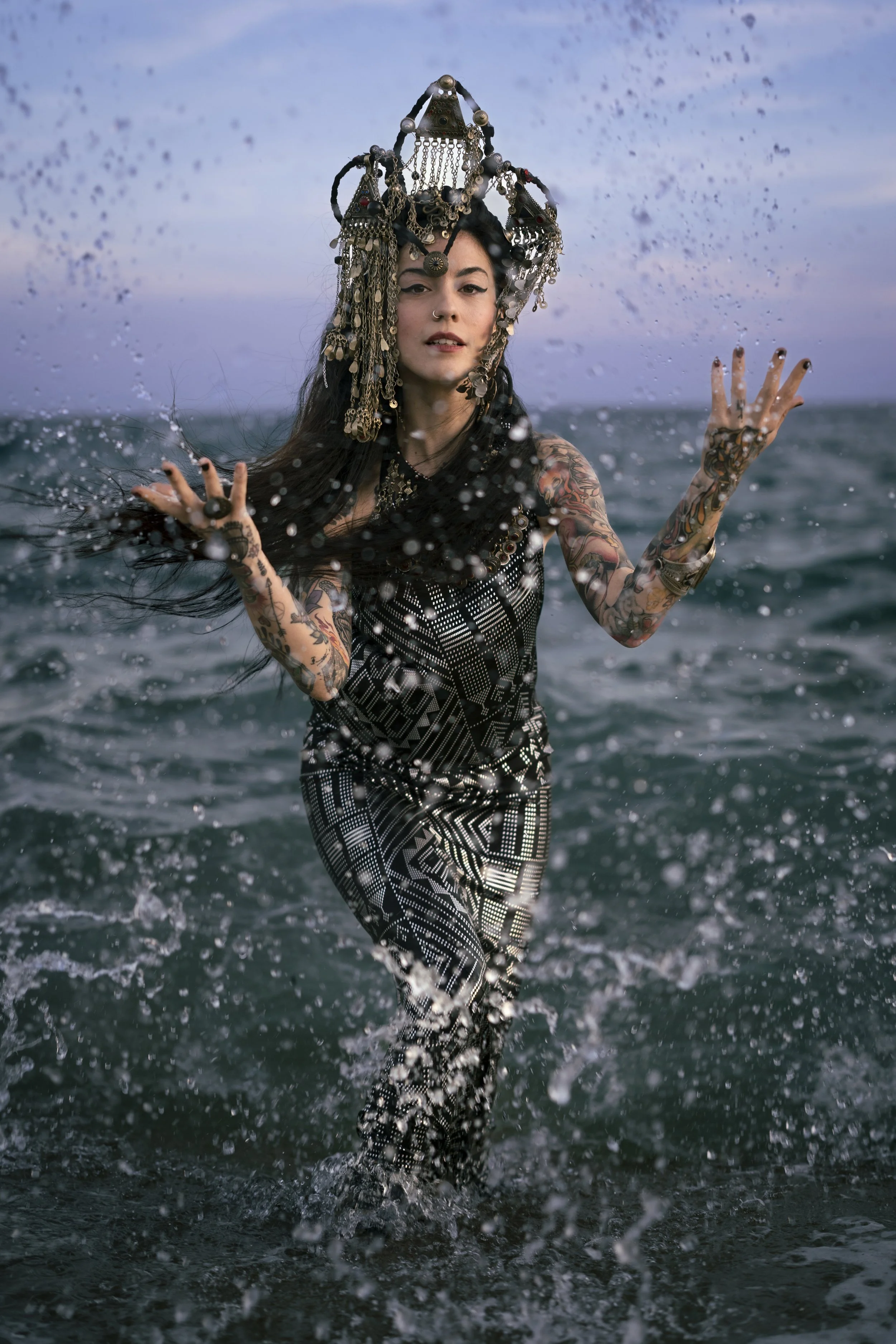 Tribal fusion dancer Sandra Roll performing on the beach in Barcelona, wearing a handcrafted crown by Olga Meos.