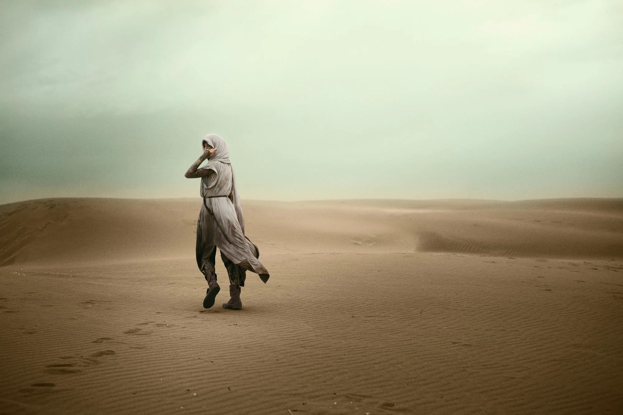 Sandra Roll walking alone across the desert in a Dune-inspired portrait