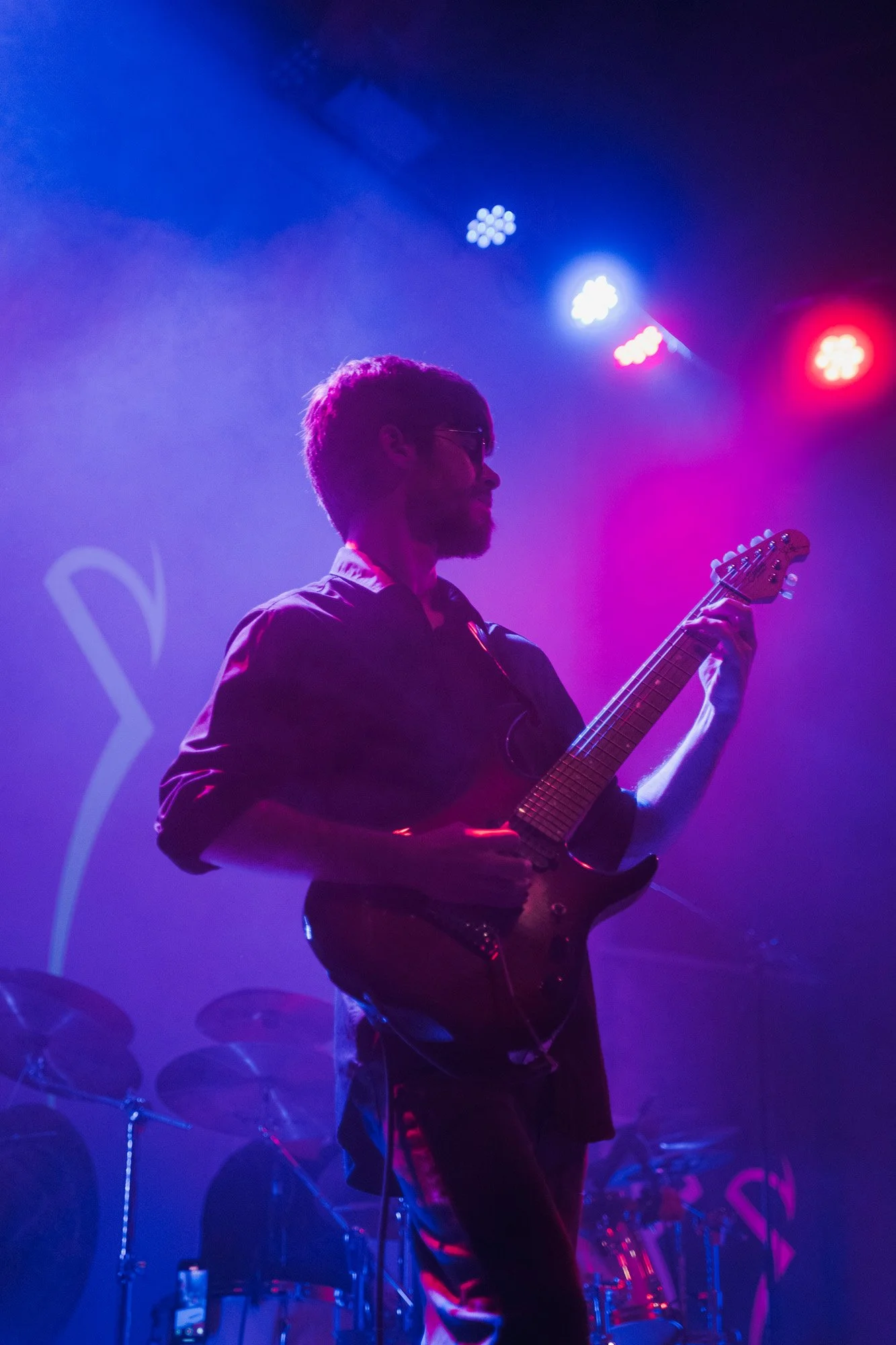 Guitarist of Serapis Project playing live on stage with dramatic lighting.