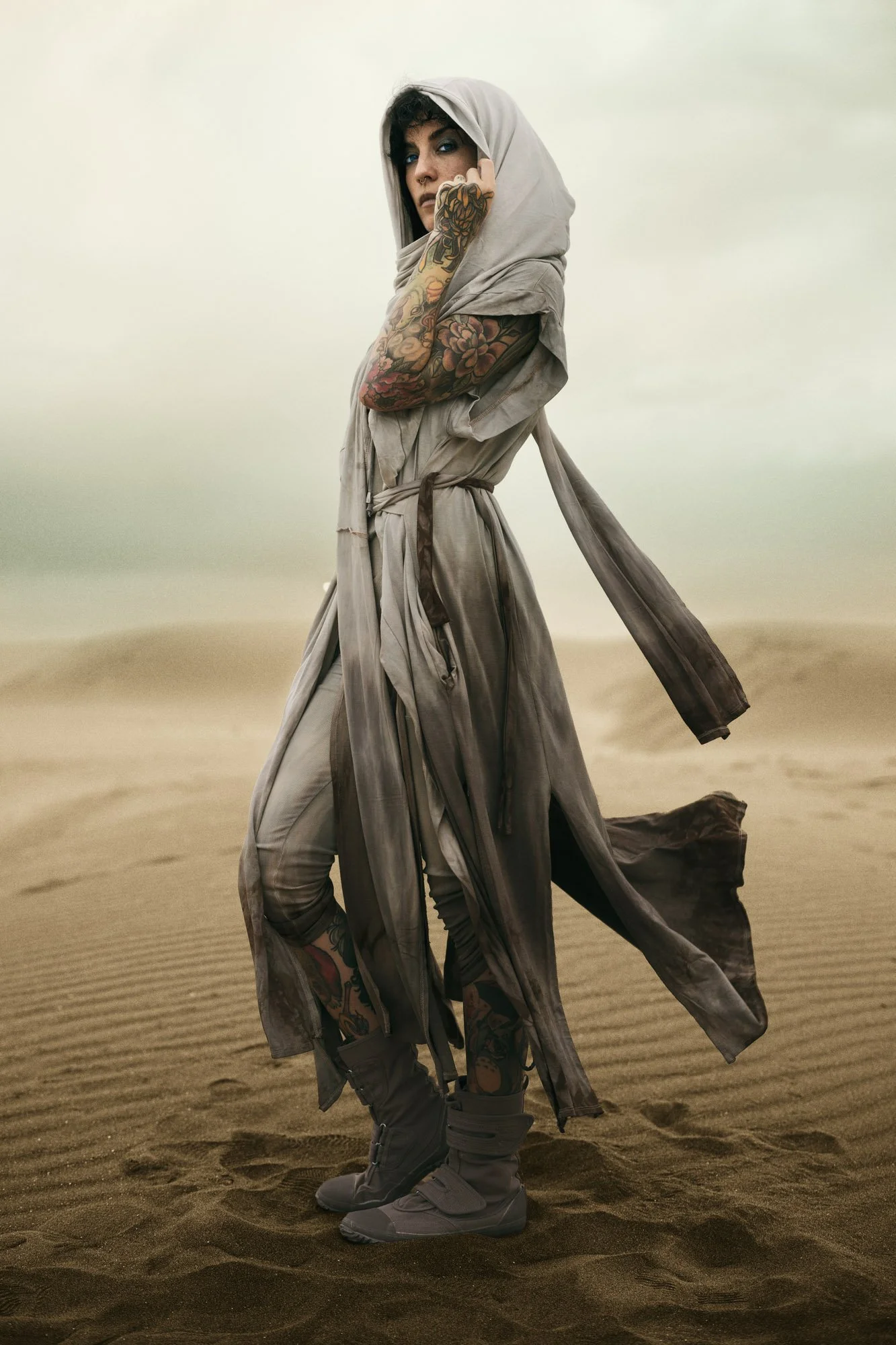 Sandra Roll as a Dune-inspired wanderer standing in the desert, wearing flowing desert clothing