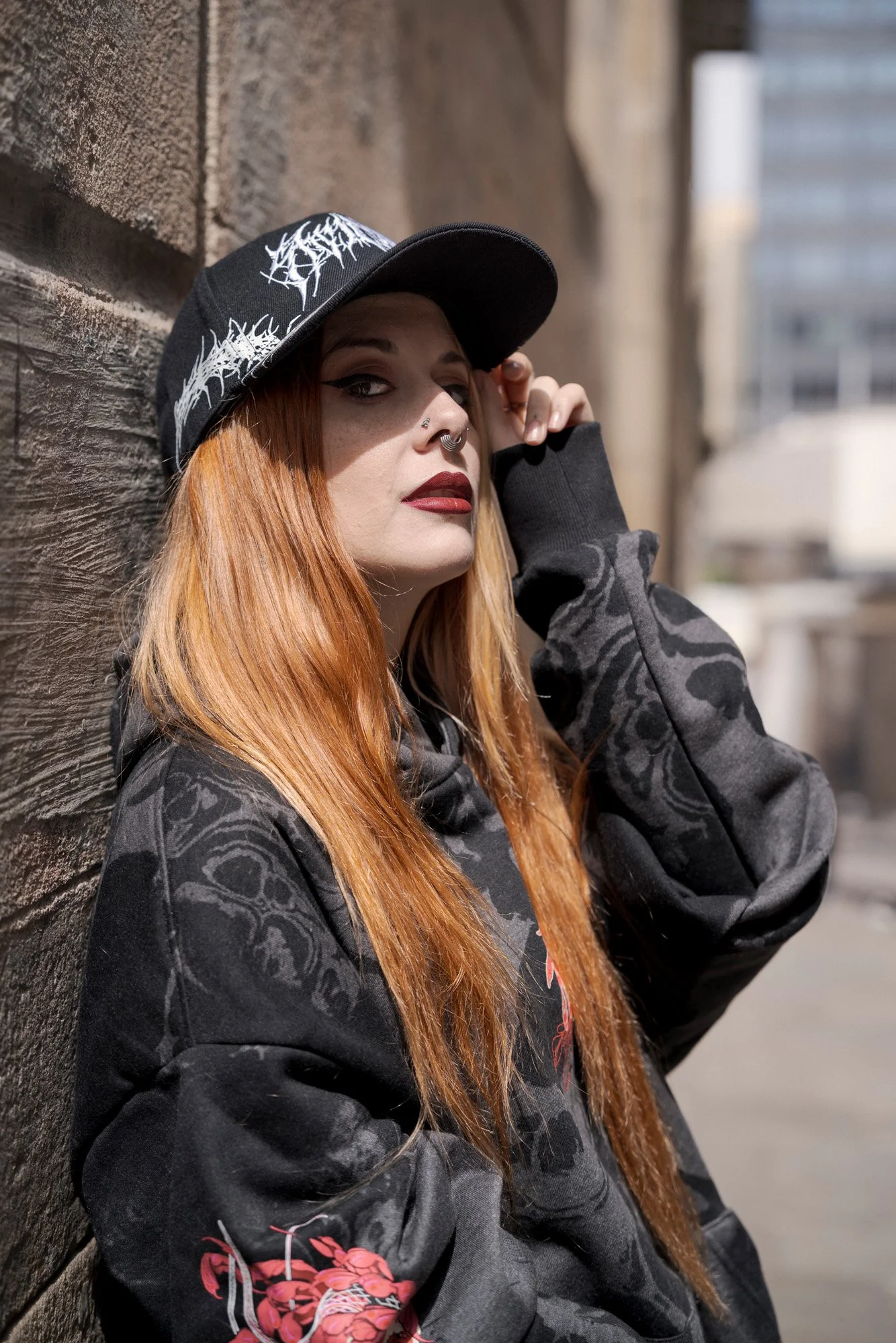 Gothic streetwear portrait of Shara Wolf in an urban stone setting.