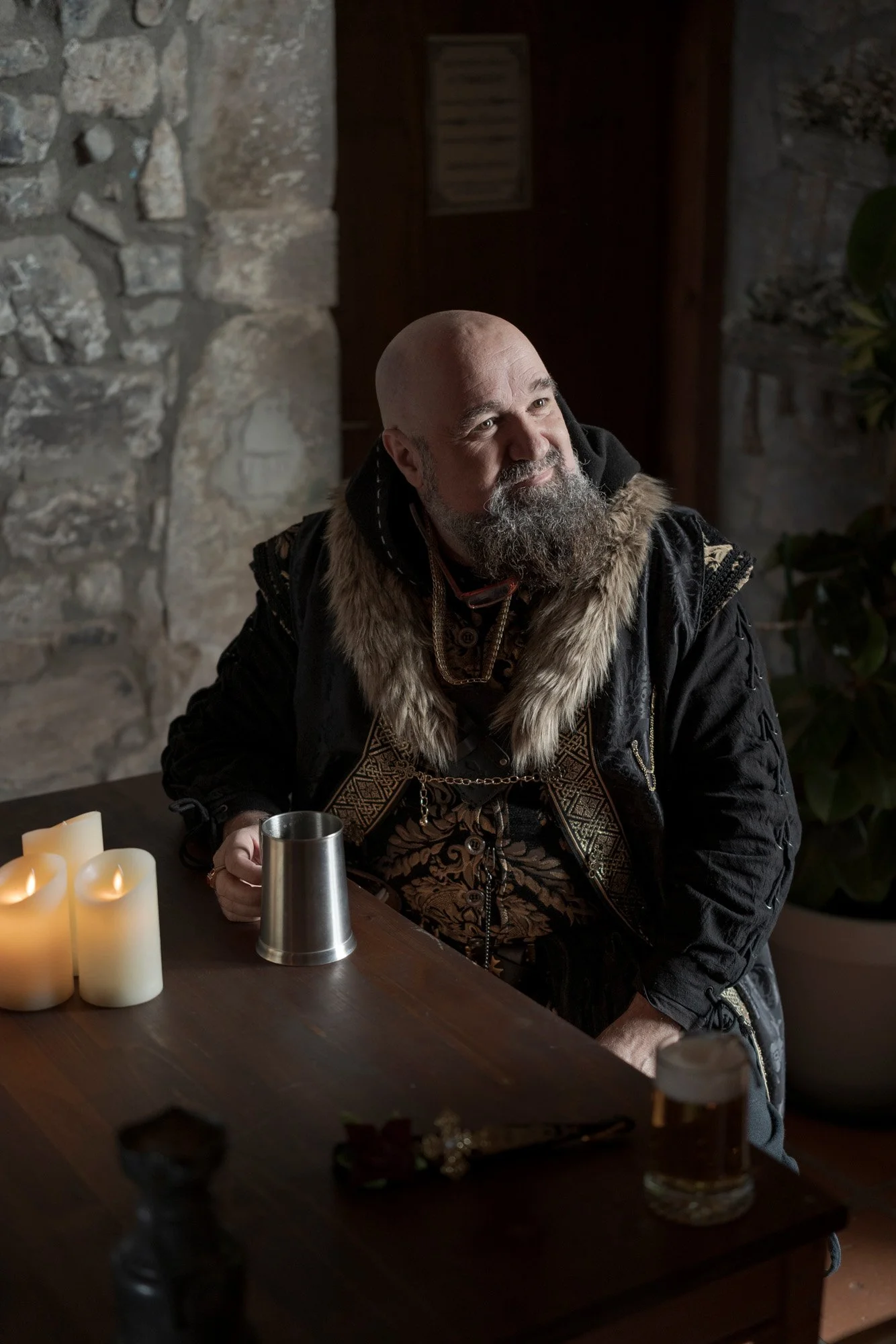 Portrait of a bearded LARP character inside a medieval-style interior, photographed during a live action role play event.