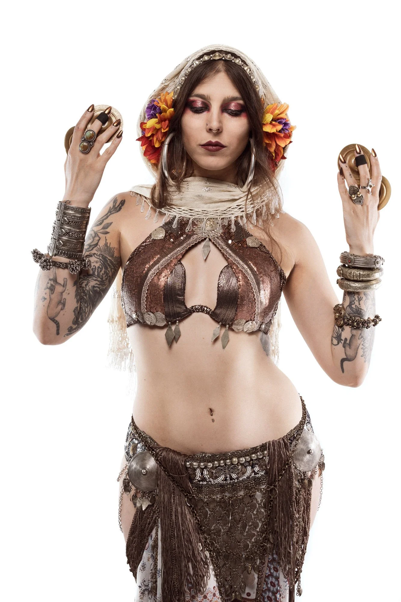 Cosmosdaughter posing with finger cymbals during artistic studio portrait session on white background