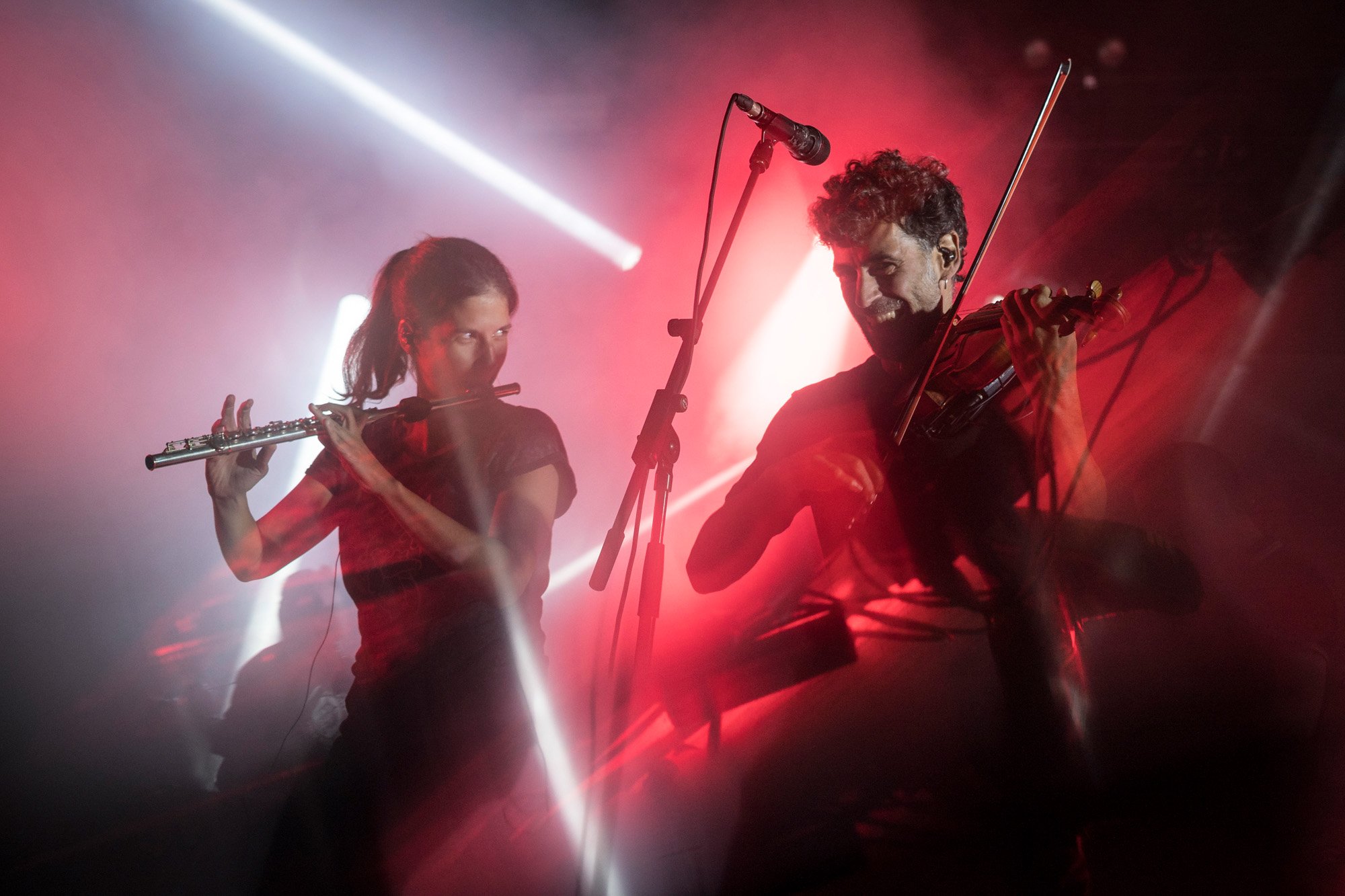 Ebri Knight performing live with energetic stage presence during a folk rock concert in Catalonia.