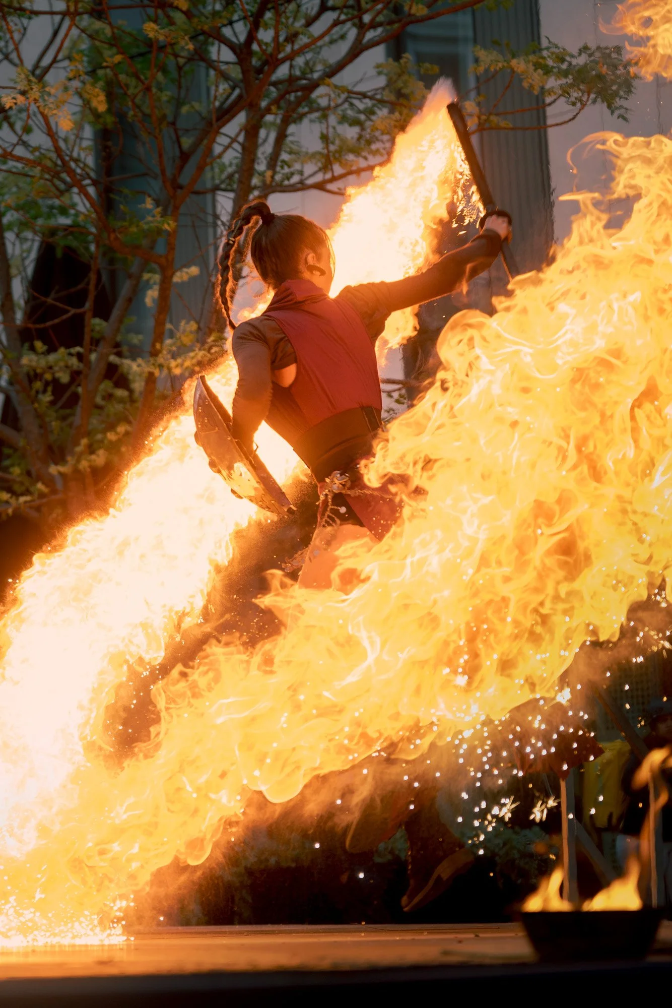 Fire performer by Pendrafoc jumping through flames in a public street event, Barcelona, Spain.