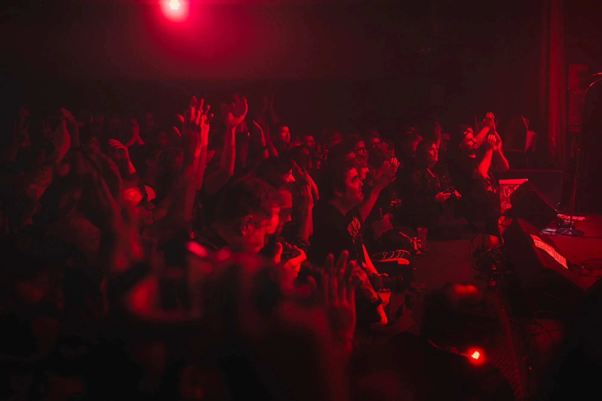 crowd reacting during live rock concert with red stage lighting