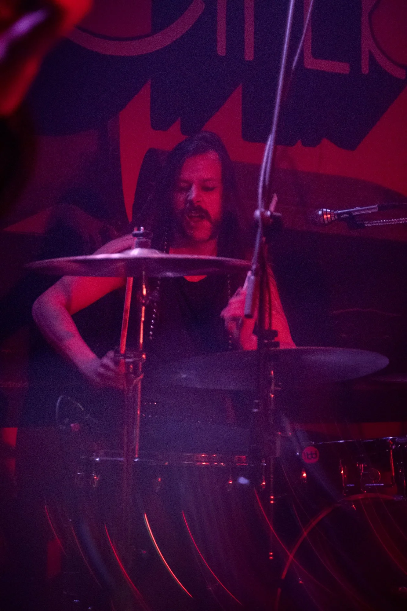 drummer playing during live rock concert under stage lighting
