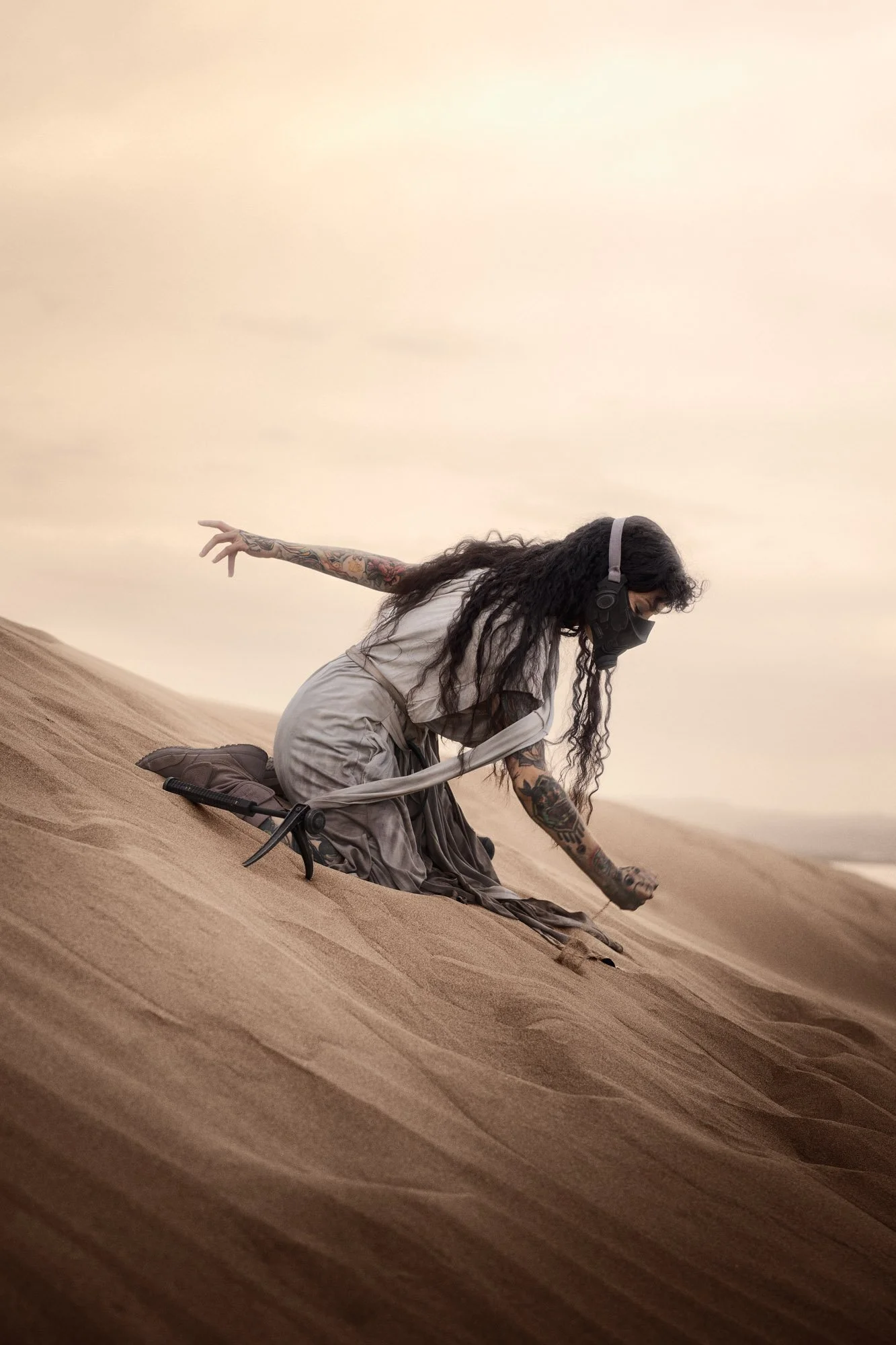 Sandra Roll moving through the sand in Fremen-inspired costume as a storm approaches
