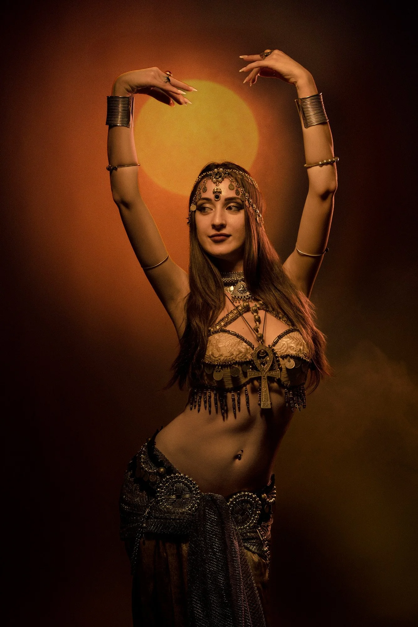 Tribal fusion dancer photographed in studio with projected sunlight and ornamental costume.