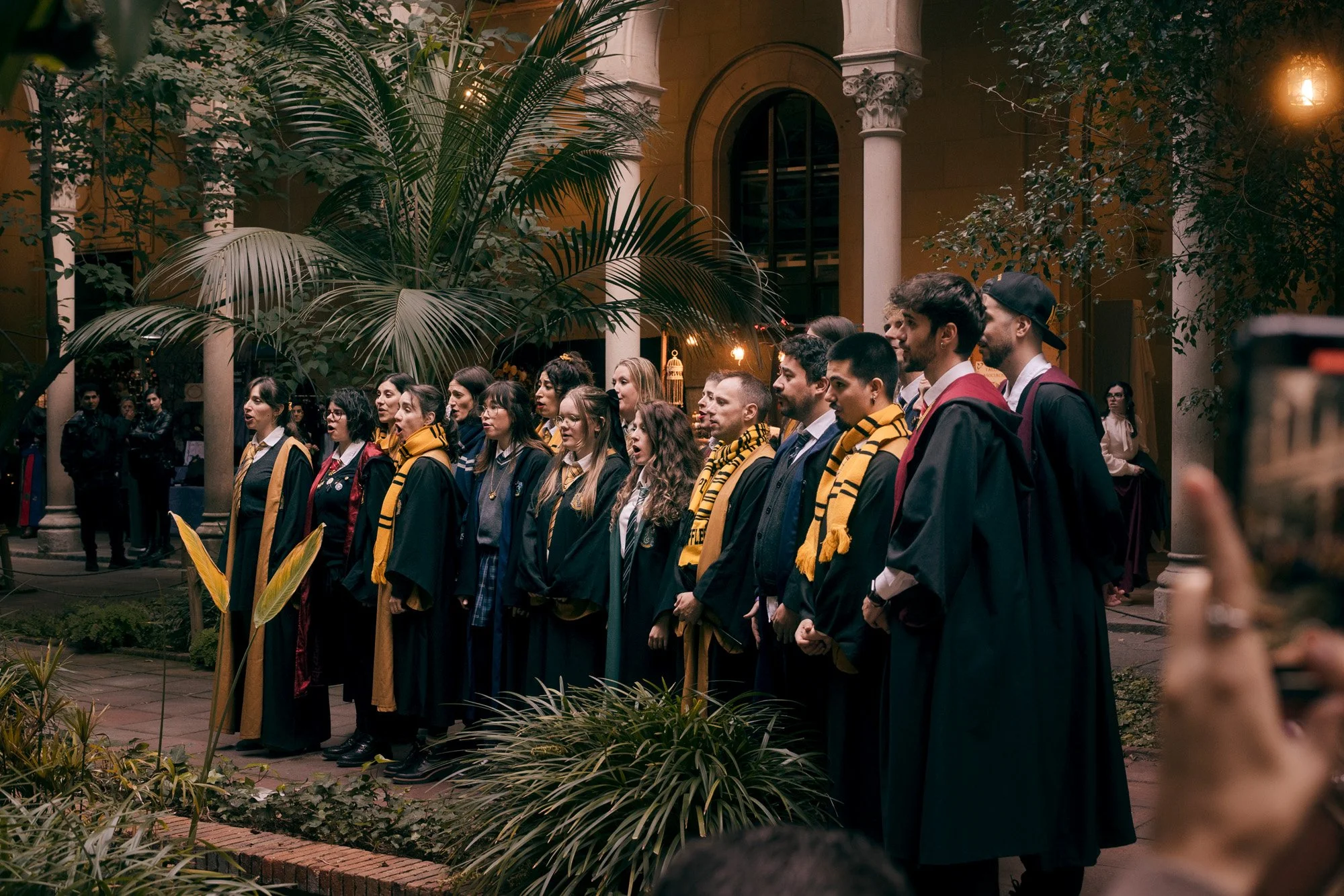 Group of fantasy cosplayers gathered outdoors during the Witch Market Barcelona, dressed as Hogwarts students.