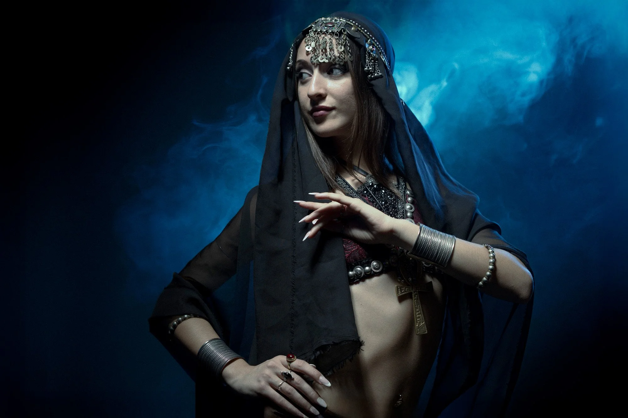 Studio portrait of Zaira MoonSun under a blue moon projection, evoking lunar calm and mystery.