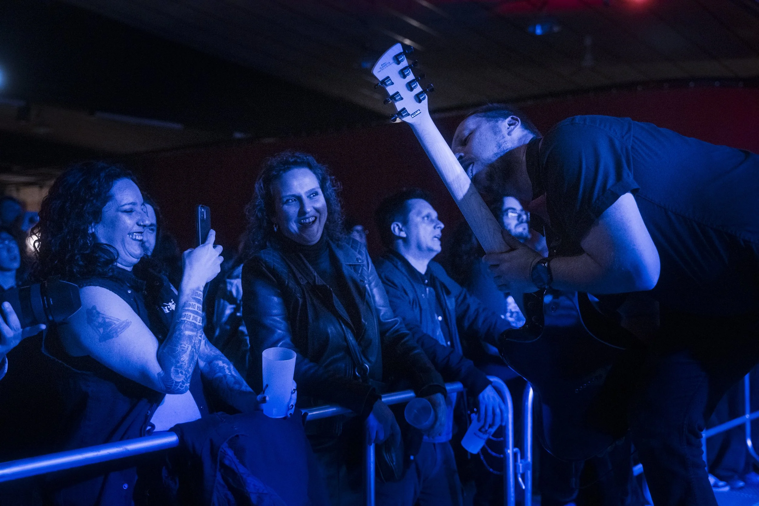 guitarist interacting with audience at front row during live metal concert