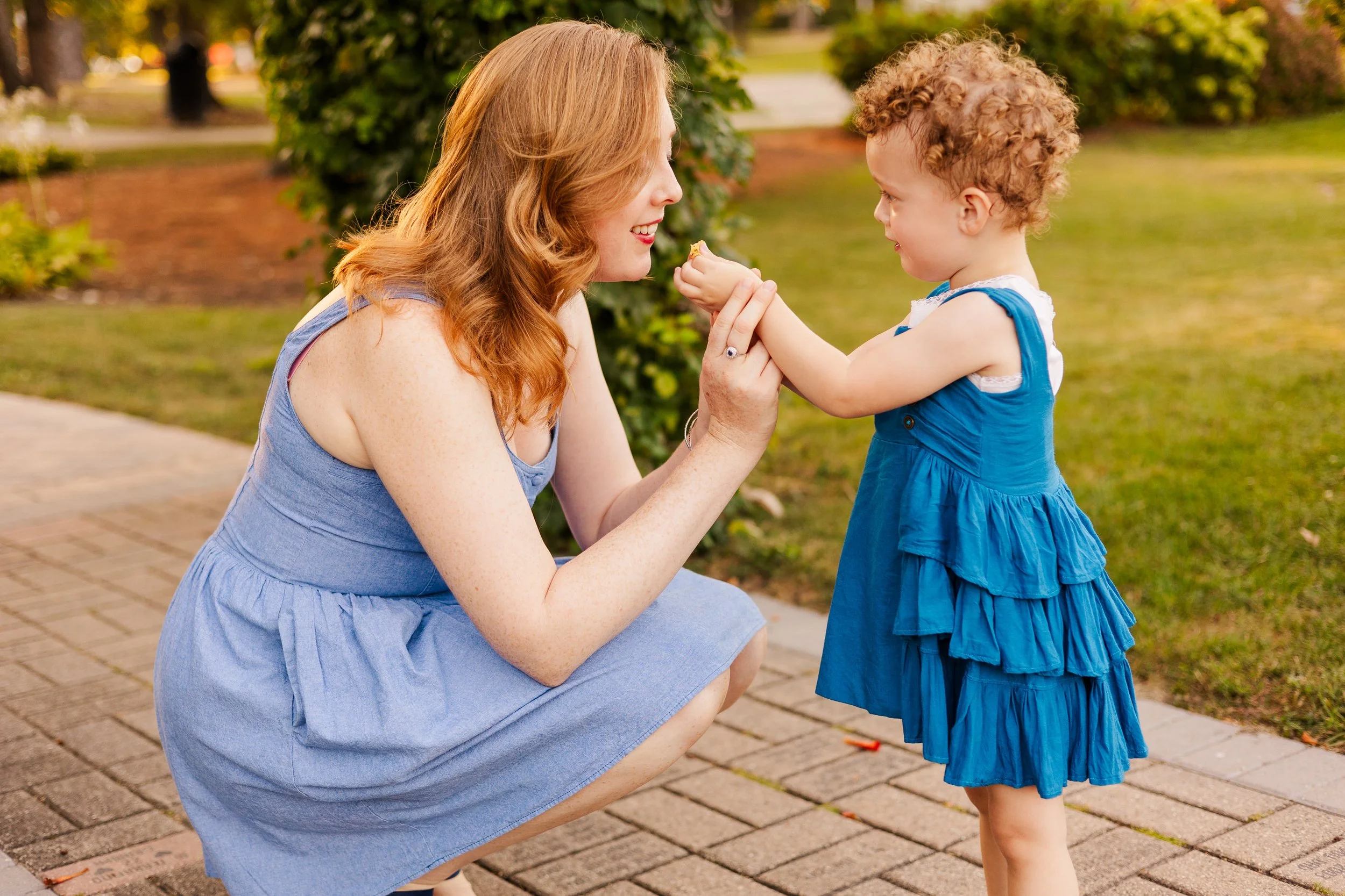 daughter has flower up to moms nose so she can smell at family photoshoot in lombard il