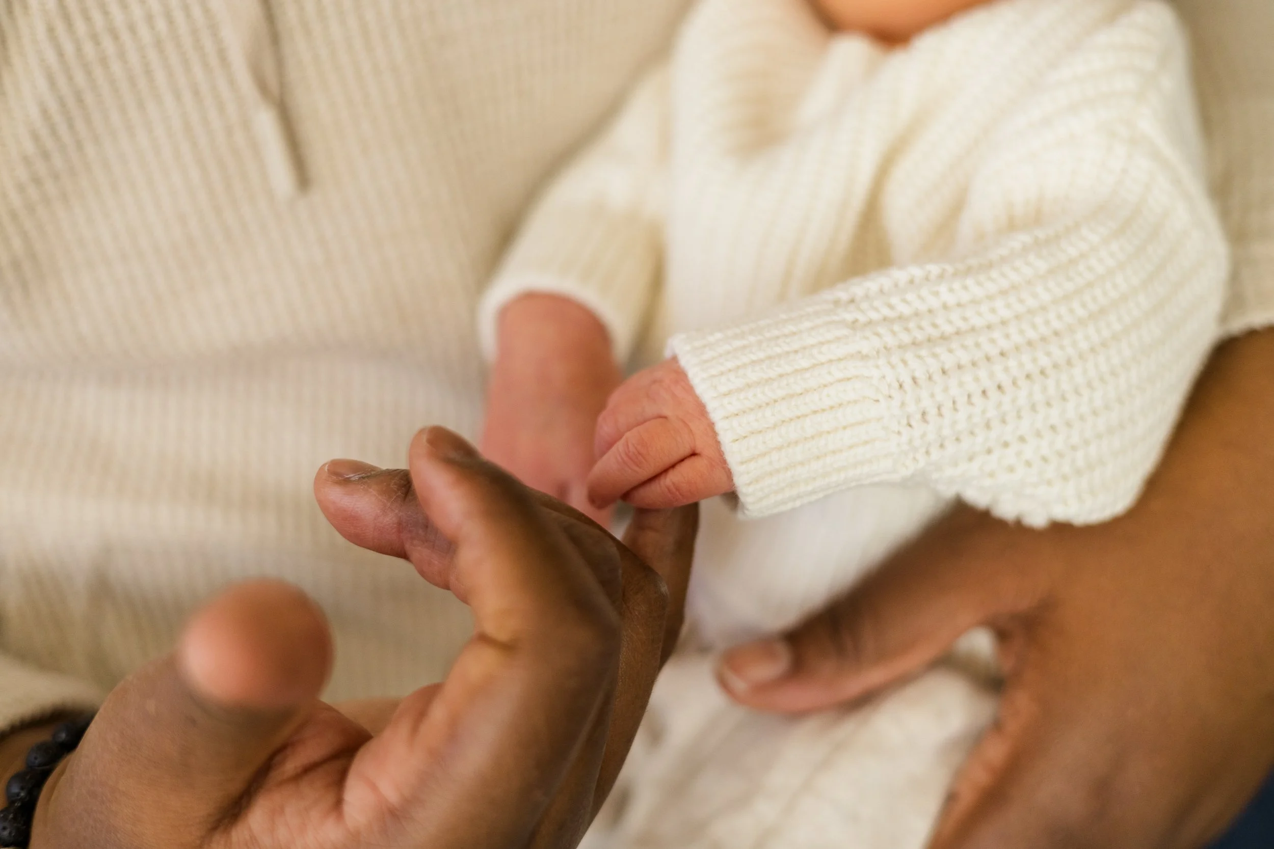 baby holding on to womans finger mommy and me session