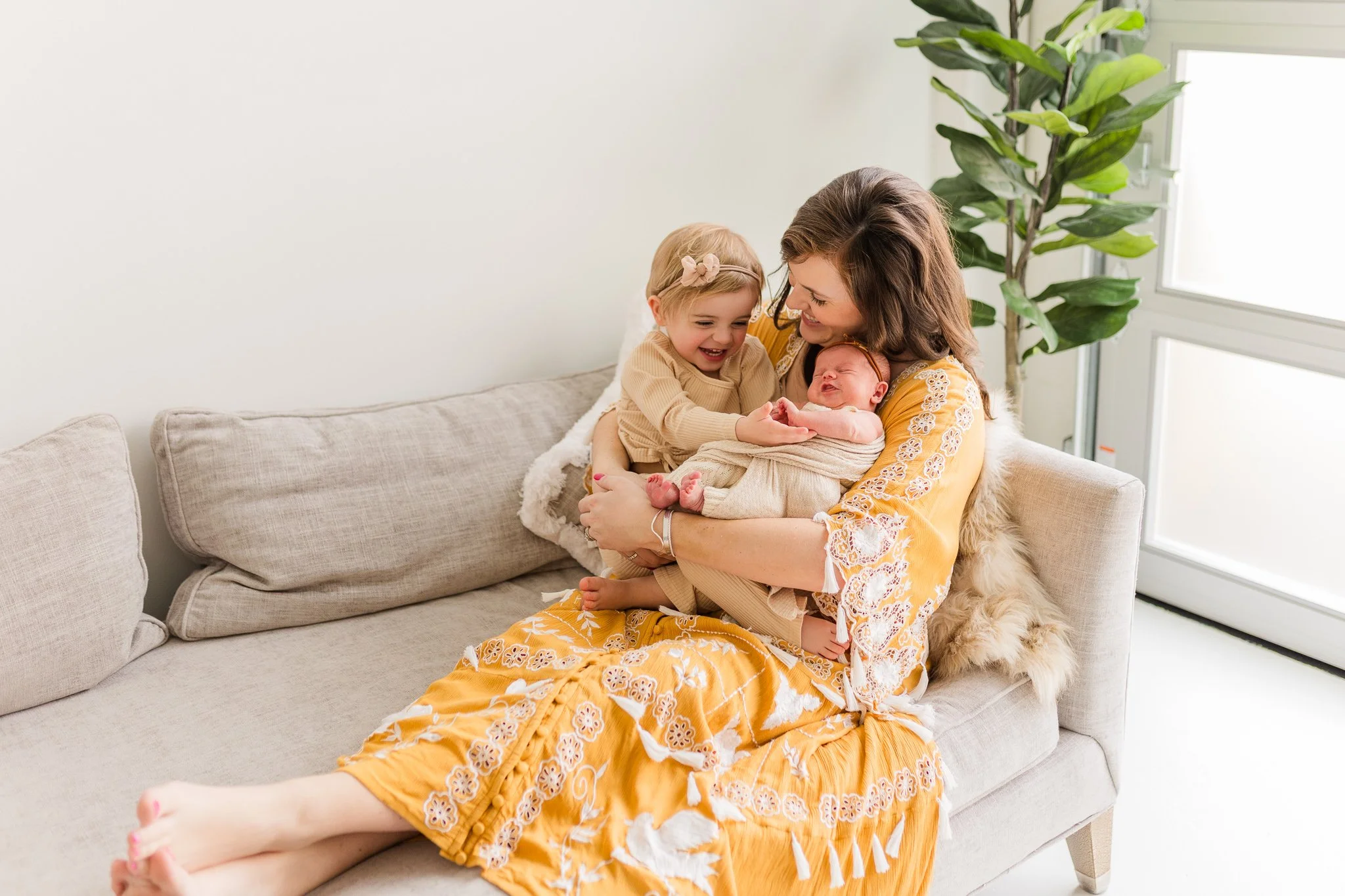 indoor newborn session with woman little girl and baby girl