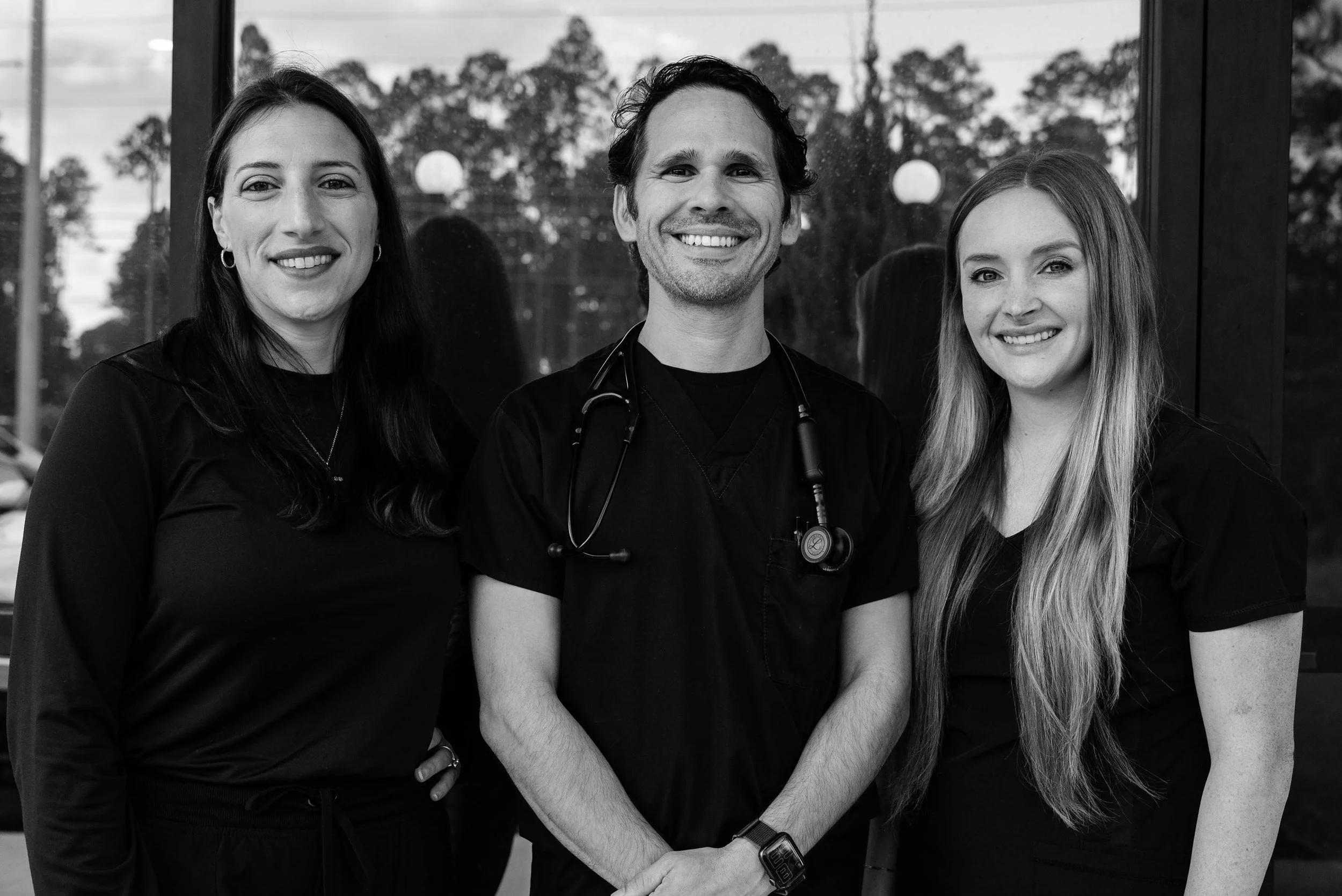Healthcare providers from R & R Collective Health smiling together outside their St. Johns, Florida office.