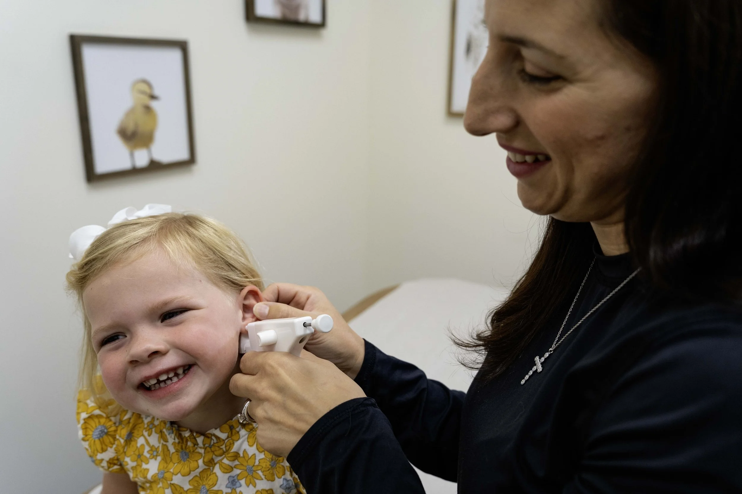 Marisa Olsen, DNP, FNP-C, performing medical ear piercing for a pediatric patient at R & R Collective Health.