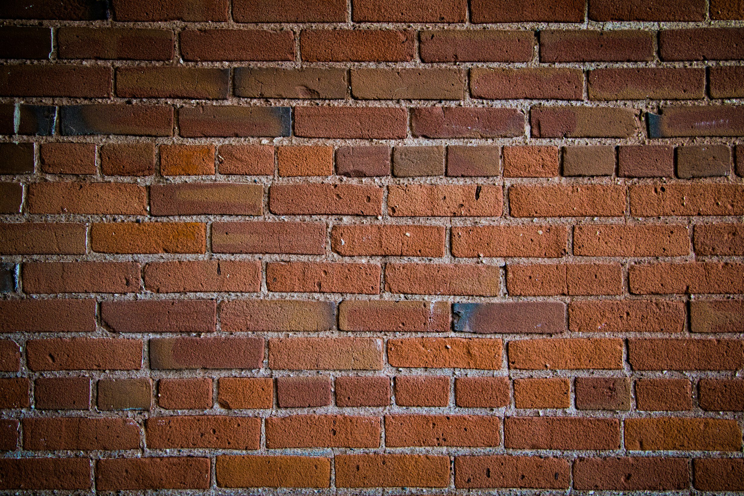 A close-up view of a red brick wall with mortar lines.