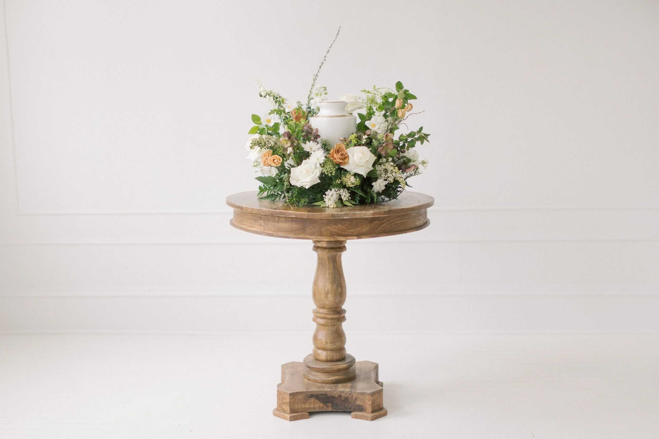 A sympathy floral arrangement designed to curve around the urn. These memorial flowers are available in Victoria BC.