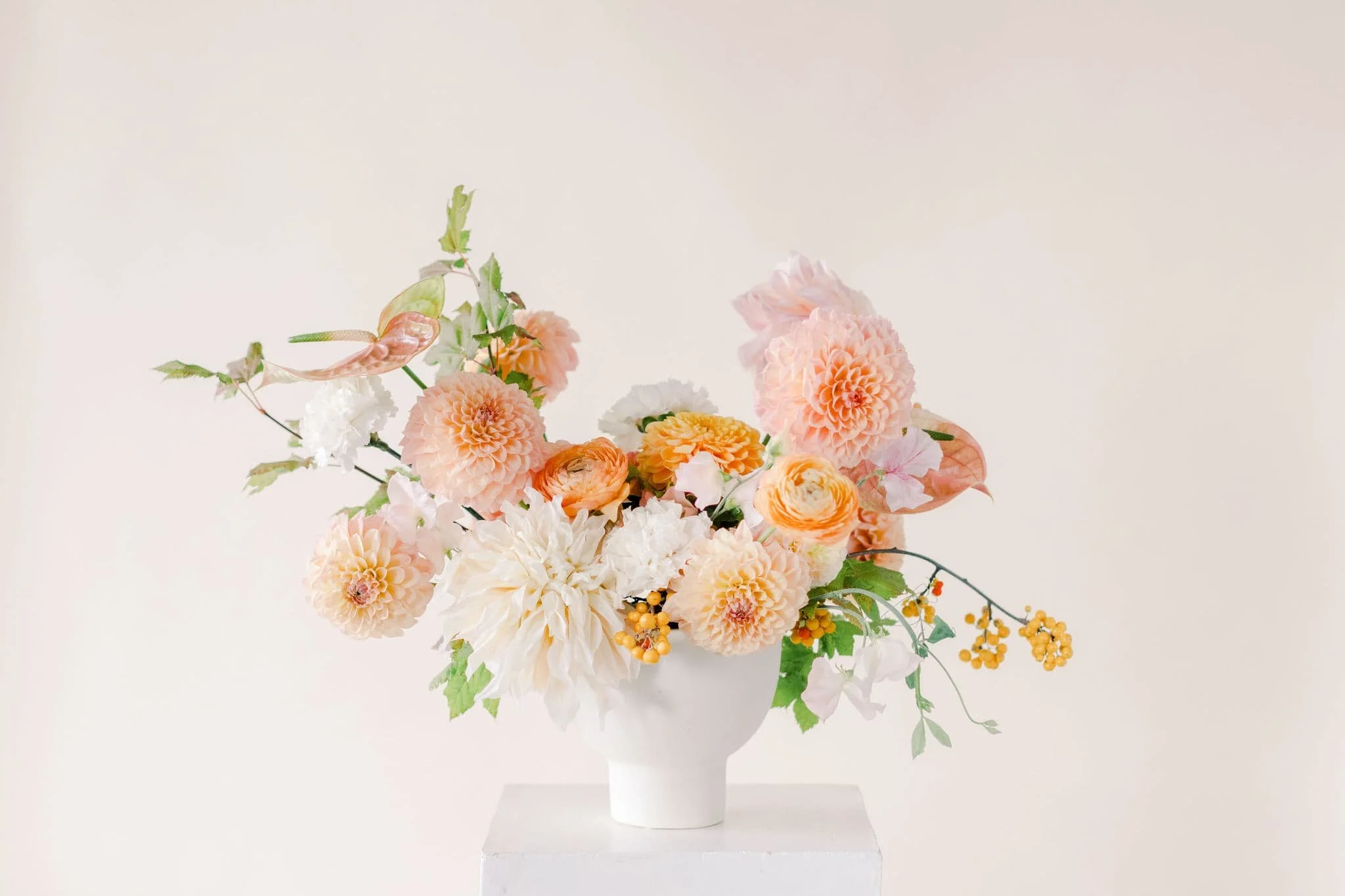 Autumn floral arrangement with pink and peach dahlias, pale pink sweet peas, coral ranunculus, and fall foliage custom designed by Twig & Bloom flower shop in Edmonton.