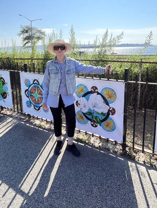 Kristin reiber Harris standing in front of her watercolor exhibit