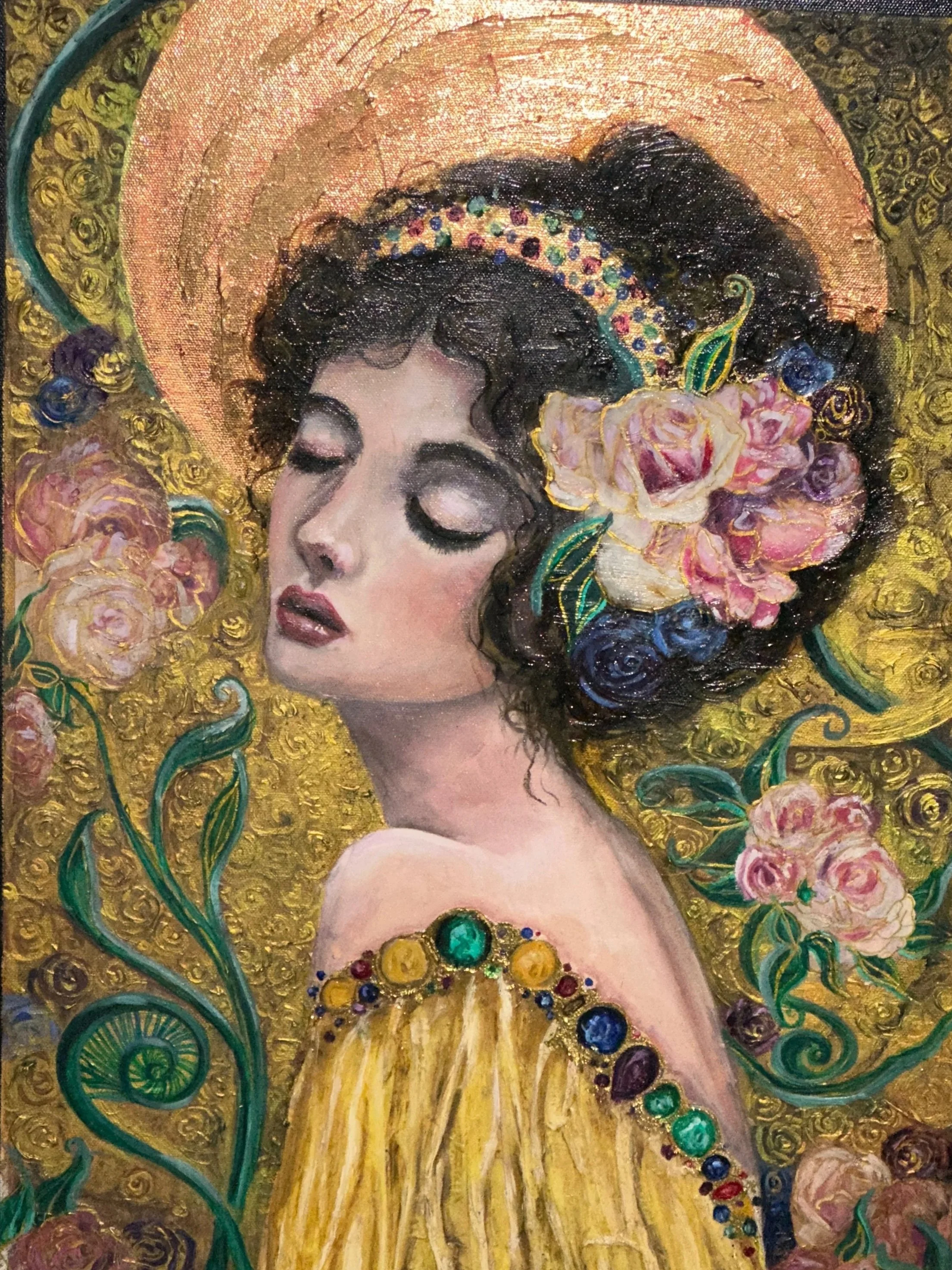 A portrait of a woman with closed eyes, dark curly hair, adorned with a colorful headband and pink flowers, wearing a yellow dress with a bejeweled neckline, set against a gold ornate background.