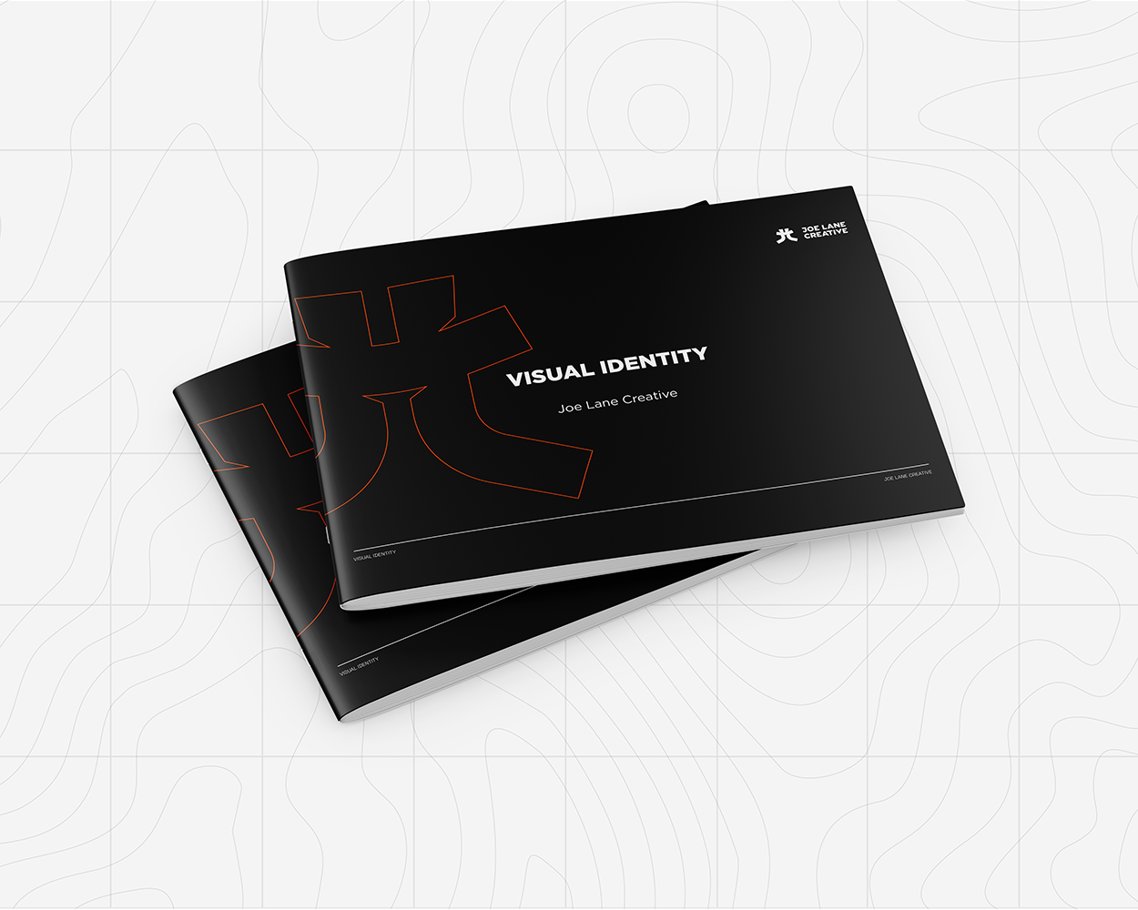 Two black hardcover books stacked on white surface, titled 'Visual Identity' by Joe Lane Creative, with a minimalist design and abstract line art on the covers.