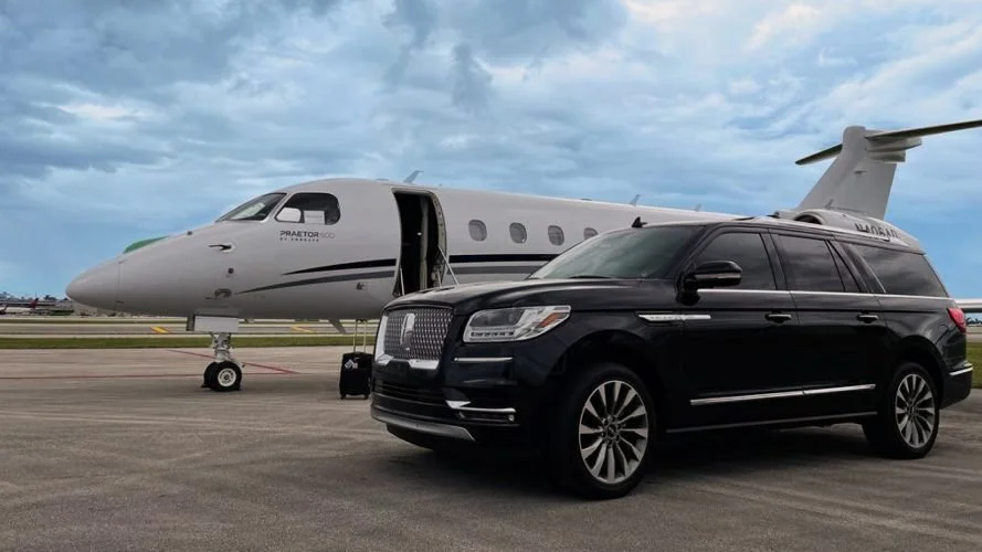 Black SUV airport transfer service at Denver International Airport with private jet on tarmac.