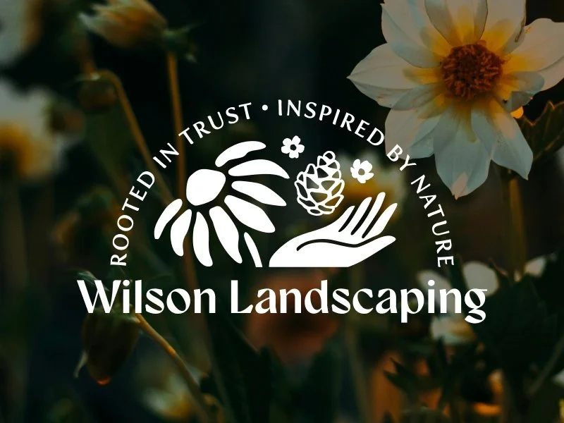 Logo for Wilson Landscaping with a stylized flower, pine cone, and hand, surrounded by the text 'Rooted in Trust - Inspired by Nature' over a blurred background of flowers.
